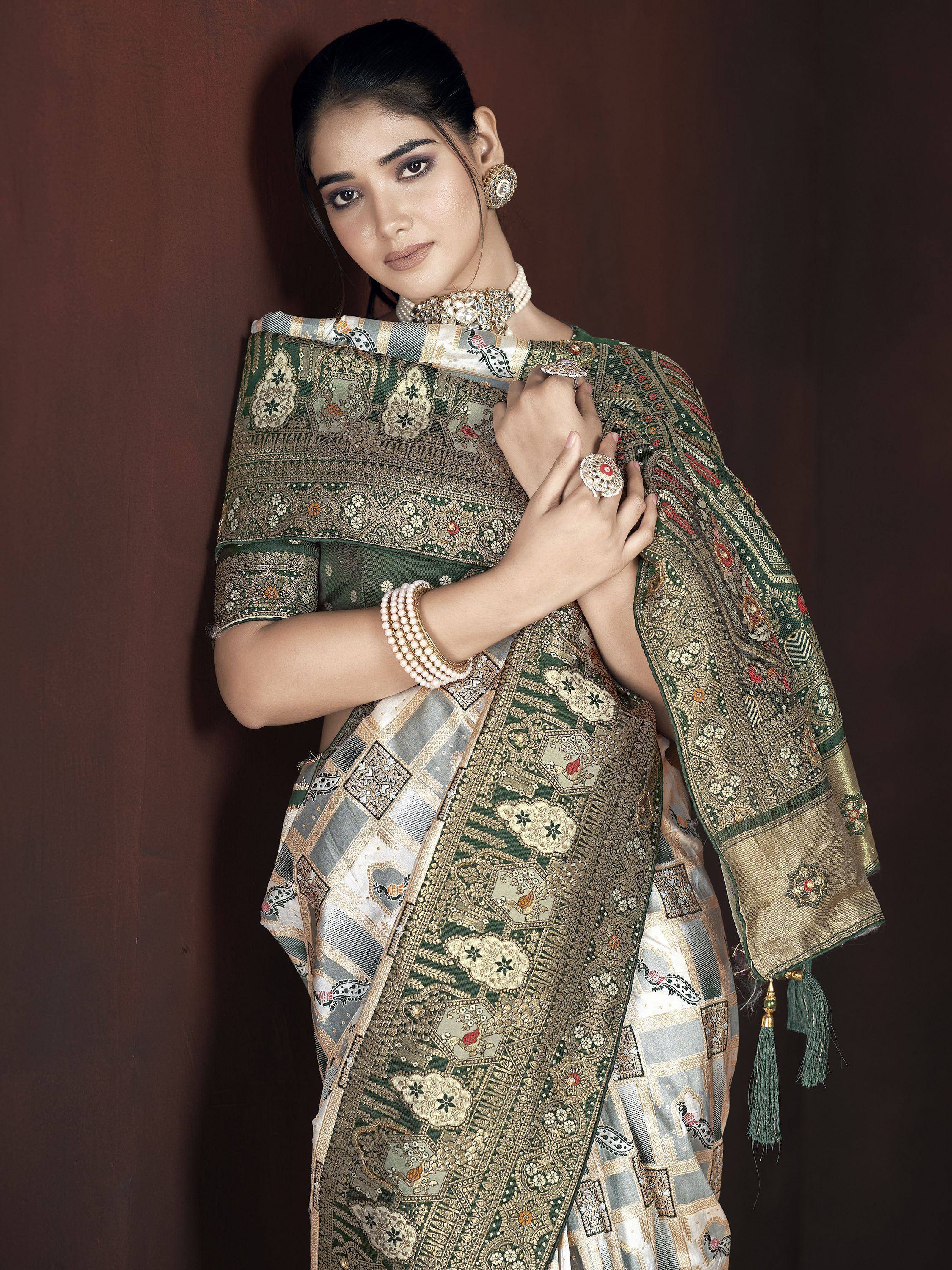 Elegant green and gold embroidered saree with intricate patterns and tassels, styled with traditional jewelry.