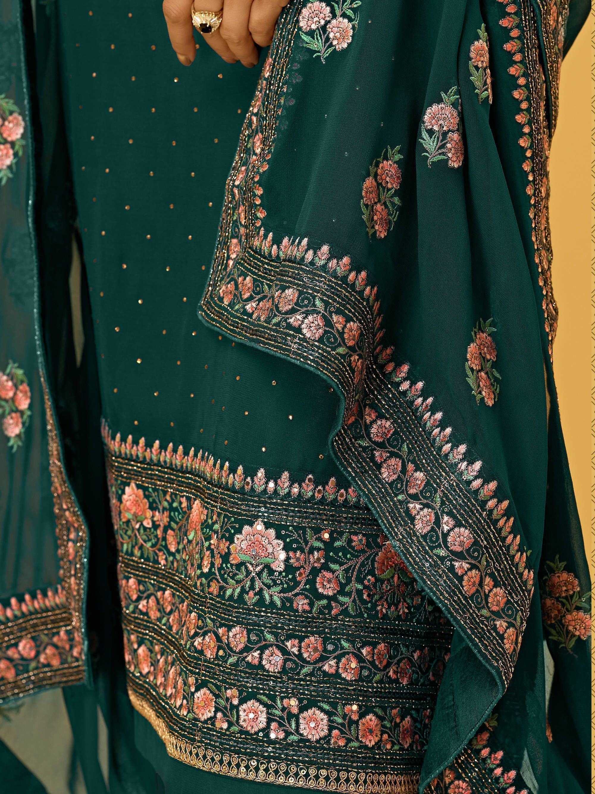 Green ethnic salwar kameez with intricate pink floral embroidery and gold accents