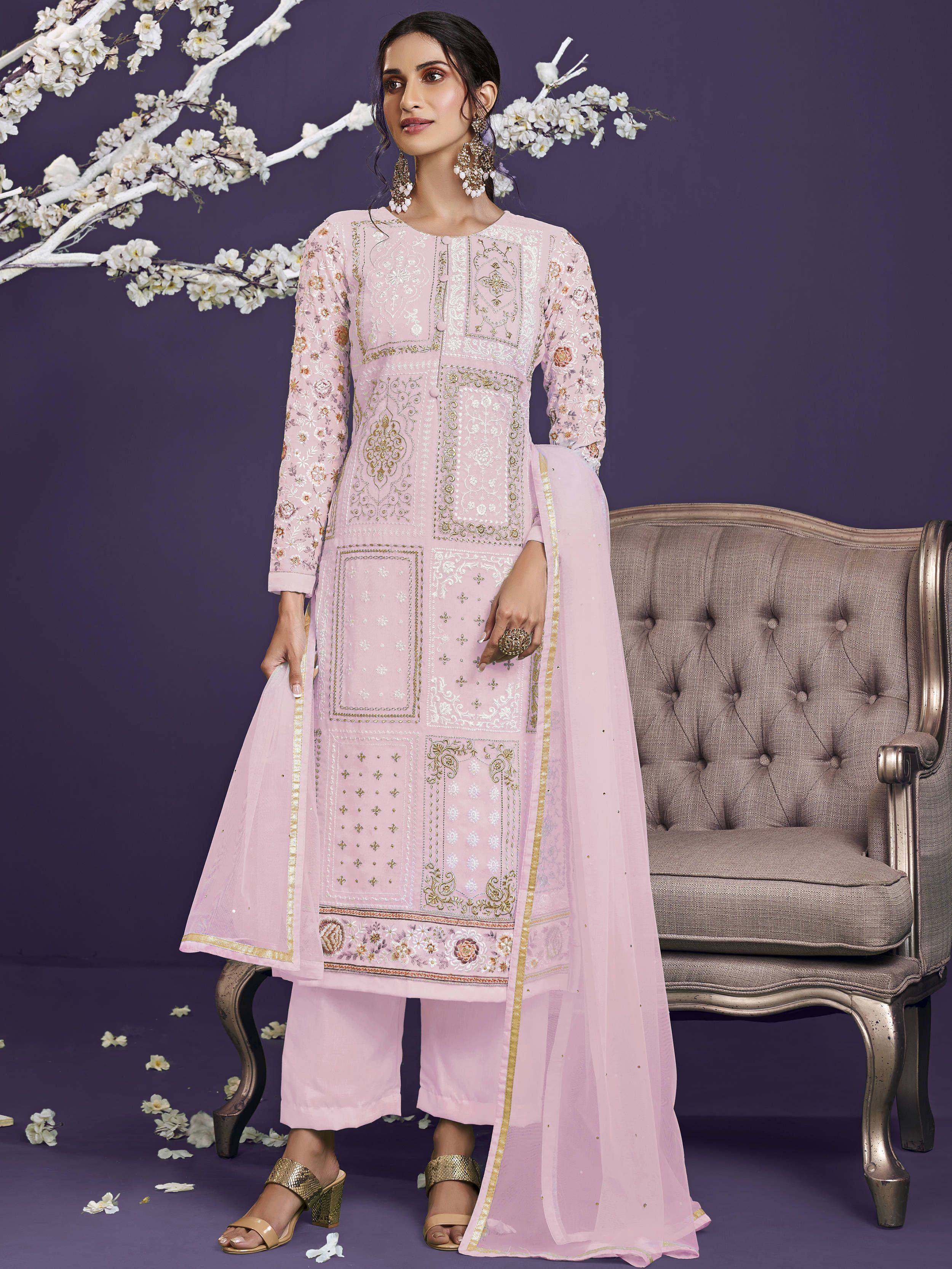 Woman in pastel pink embroidered salwar kameez with dupatta, floral decor background