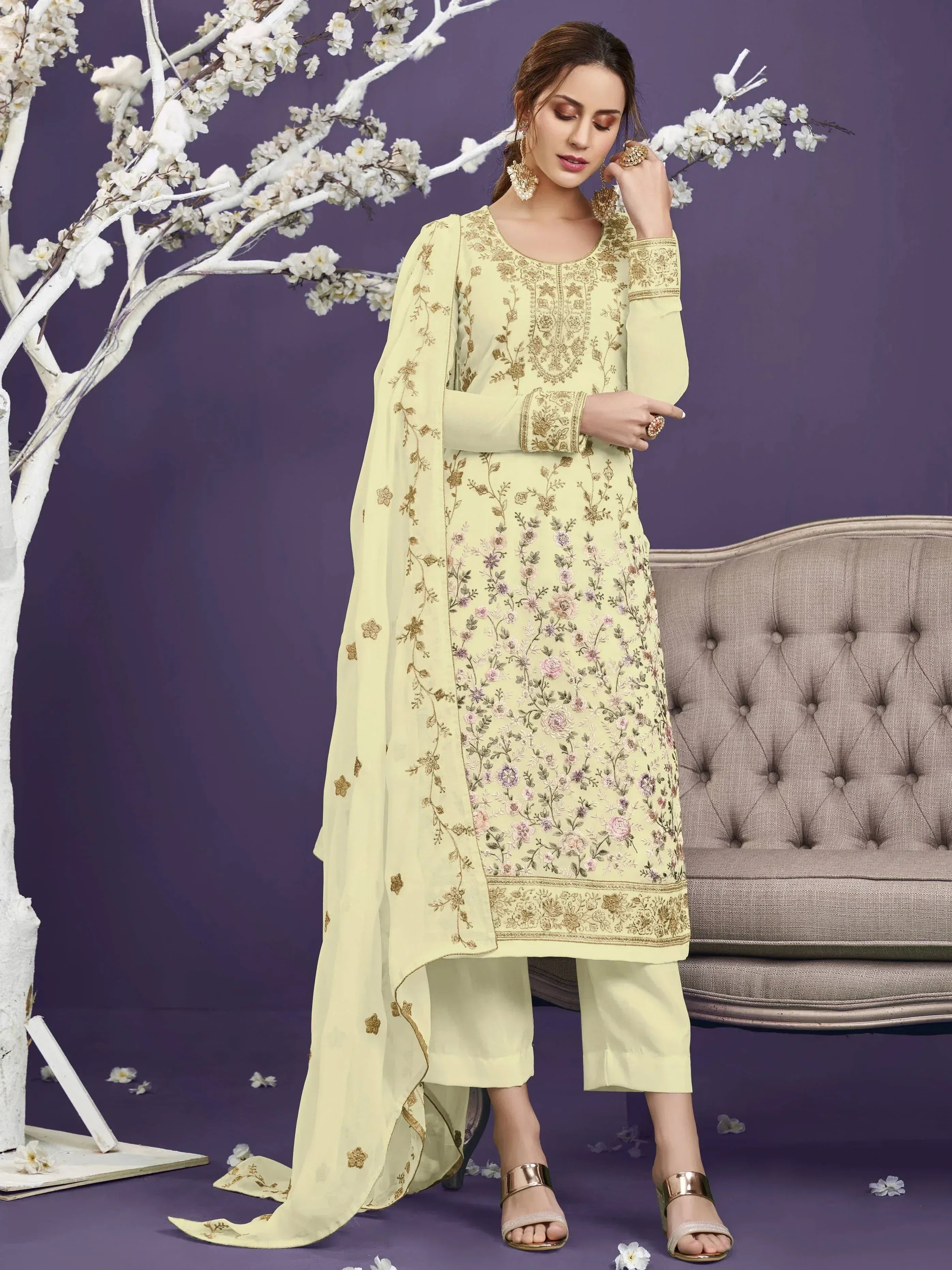 Woman wearing pastel yellow embroidered salwar kameez with dupatta, floral accents, ethnic fashion