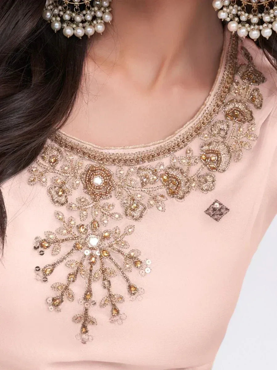 Elegant pink ethnic top with intricate gold floral embroidery and pearl embellishments, perfect for Indian weddings.