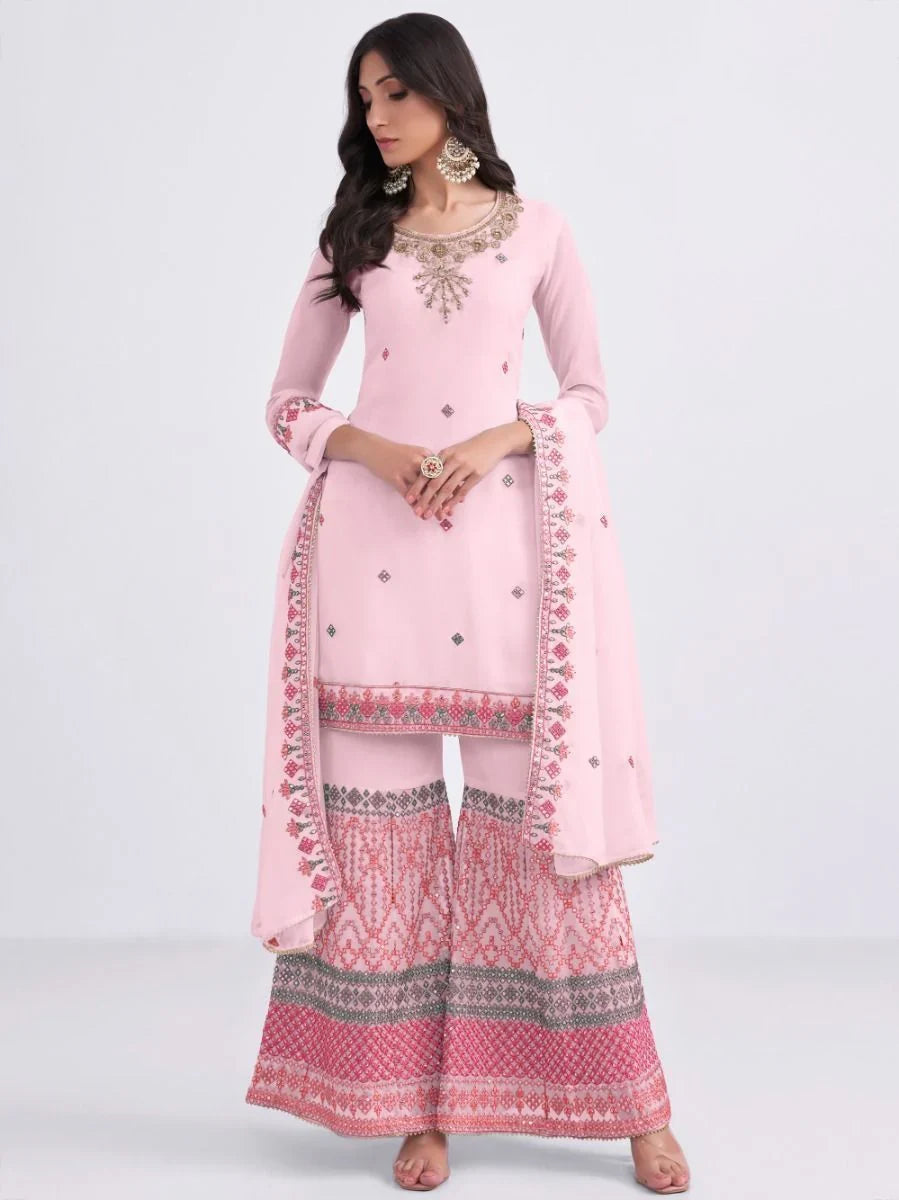 Woman wearing a light pink embroidered salwar kameez with palazzo pants and dupatta