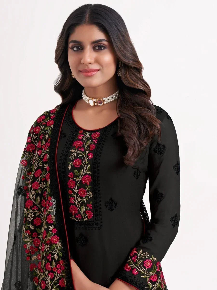 Woman wearing black salwar kameez with red floral embroidery and sheer dupatta