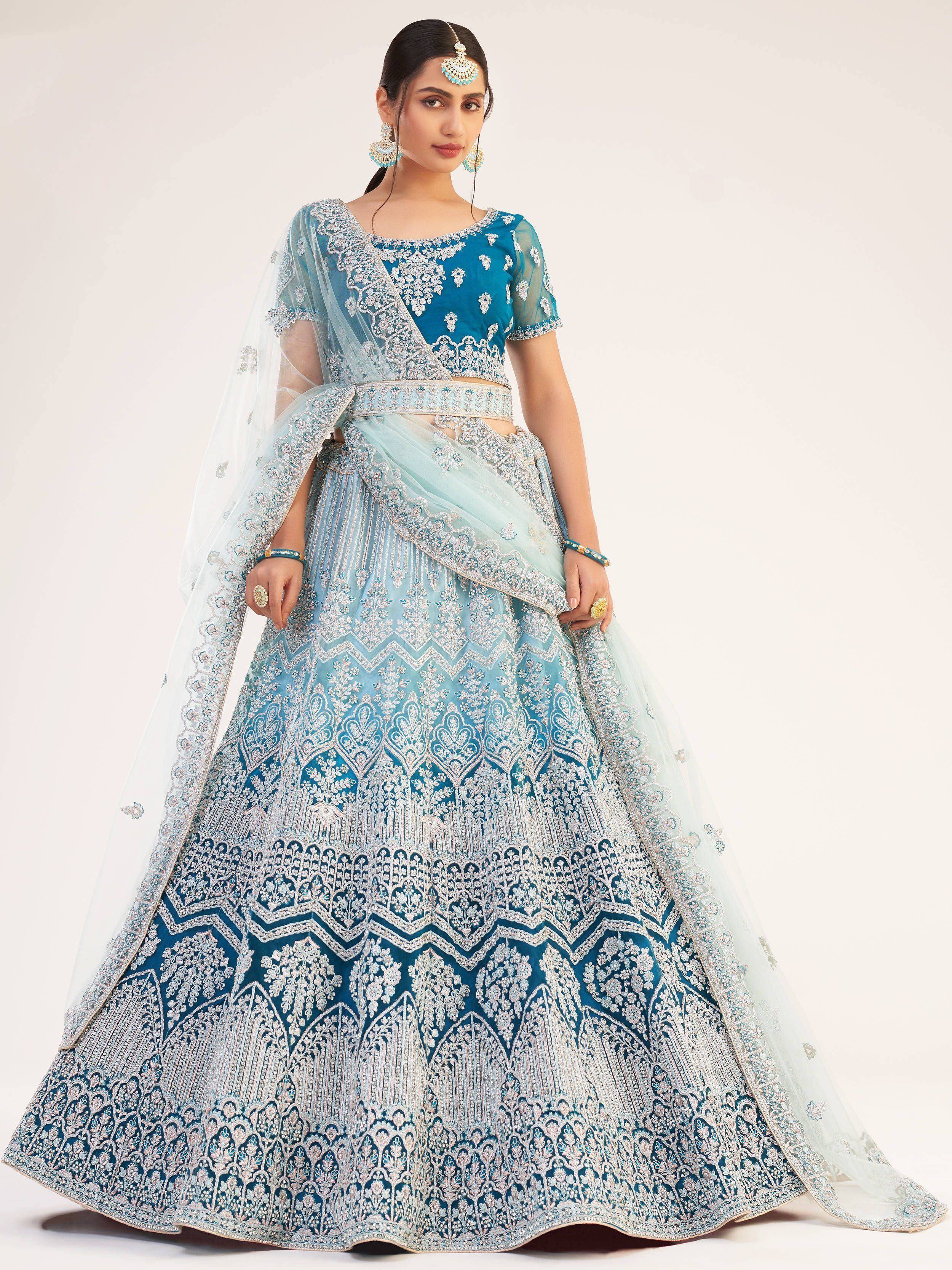 Blue designer lehenga choli with intricate silver embroidery and sheer dupatta, perfect for Indian weddings and festive occasions.