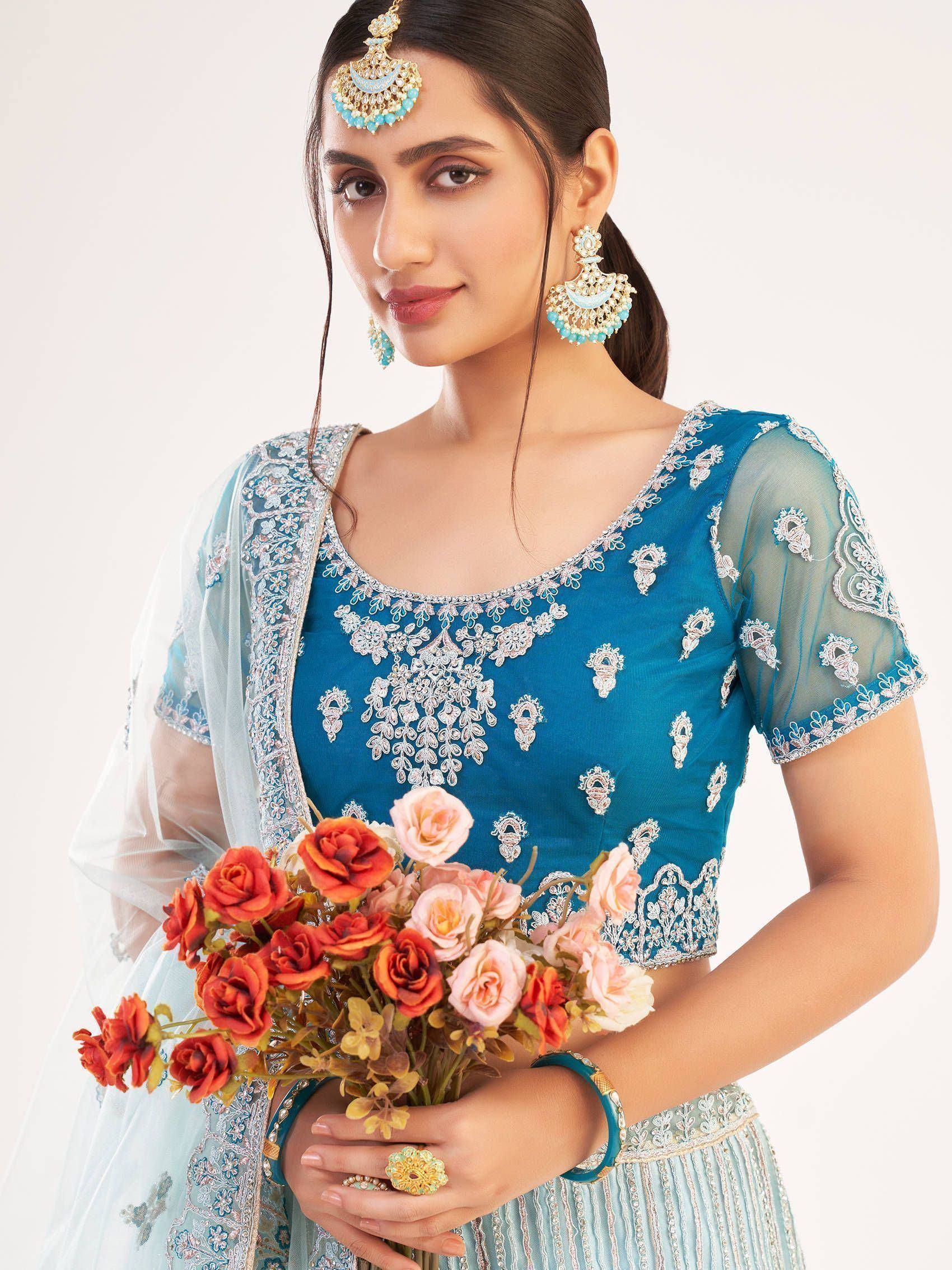 Blue embroidered lehenga choli with matching jewelry and floral bouquet, ideal for Indian ethnic occasions