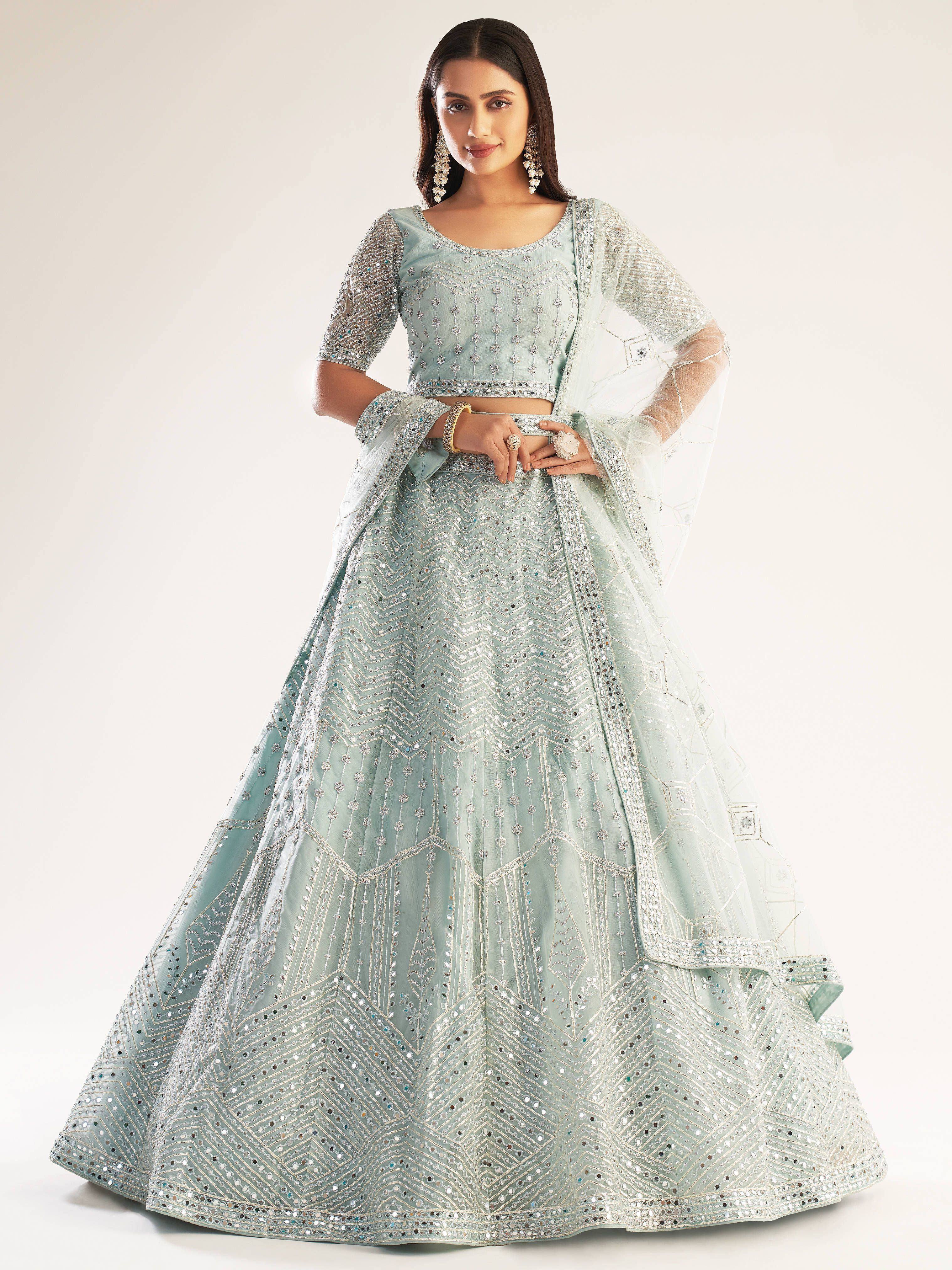Mint green designer lehenga choli with intricate mirror work and sheer dupatta, perfect for Indian ethnic occasions.