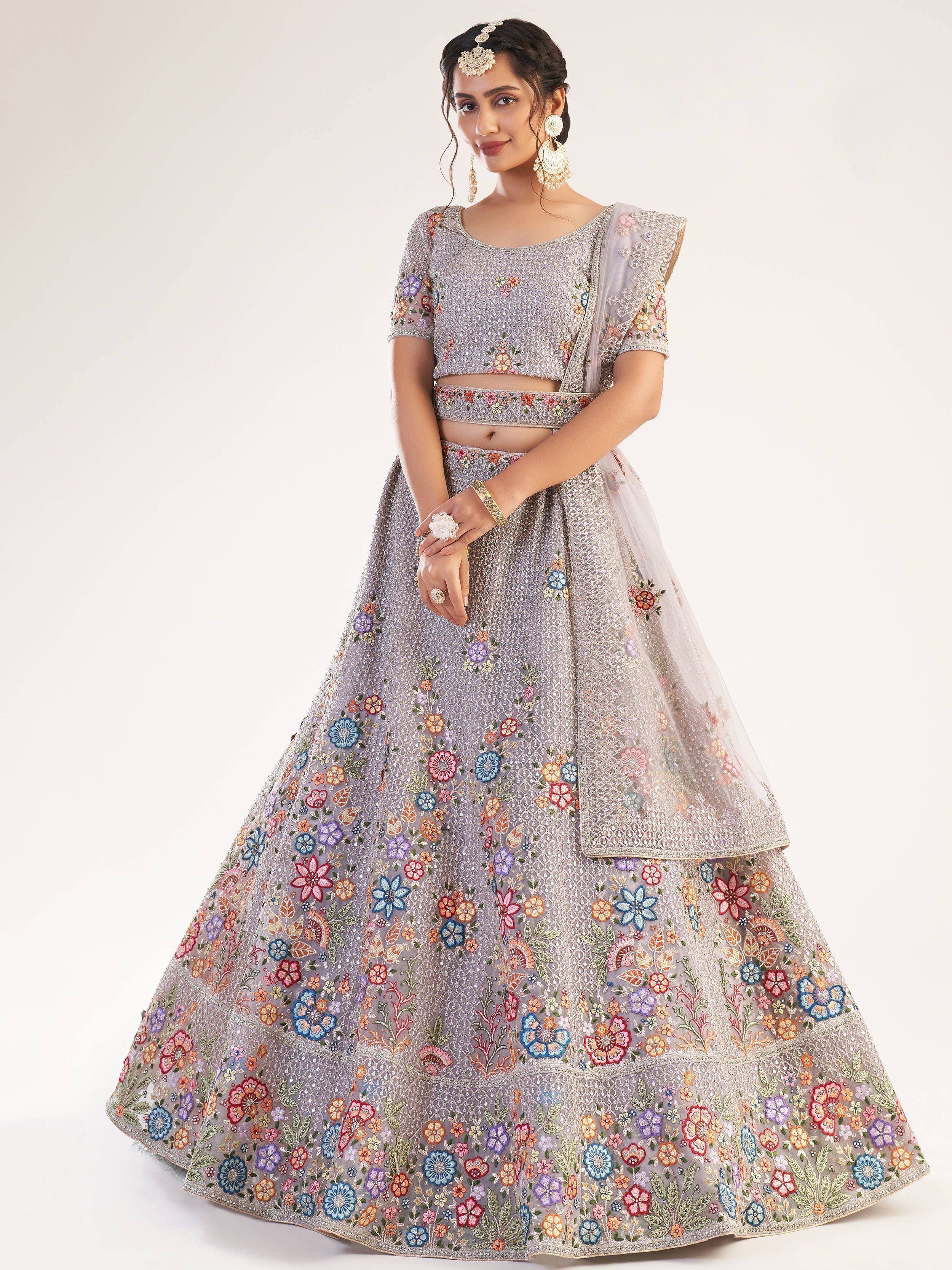 Elegant lavender lehenga choli with colorful floral embroidery and sheer dupatta, perfect for Indian weddings and festive occasions.