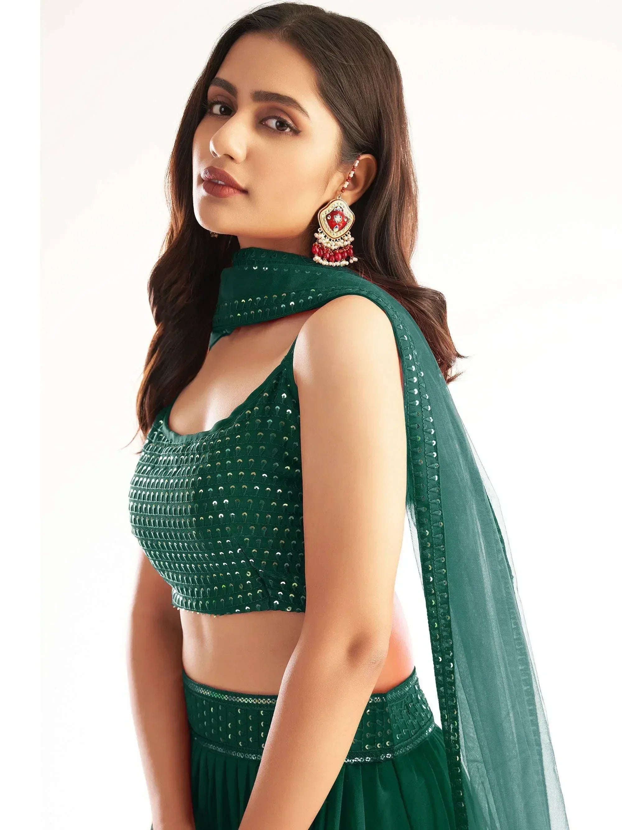 Emerald green sequined lehenga choli with matching dupatta and statement earrings