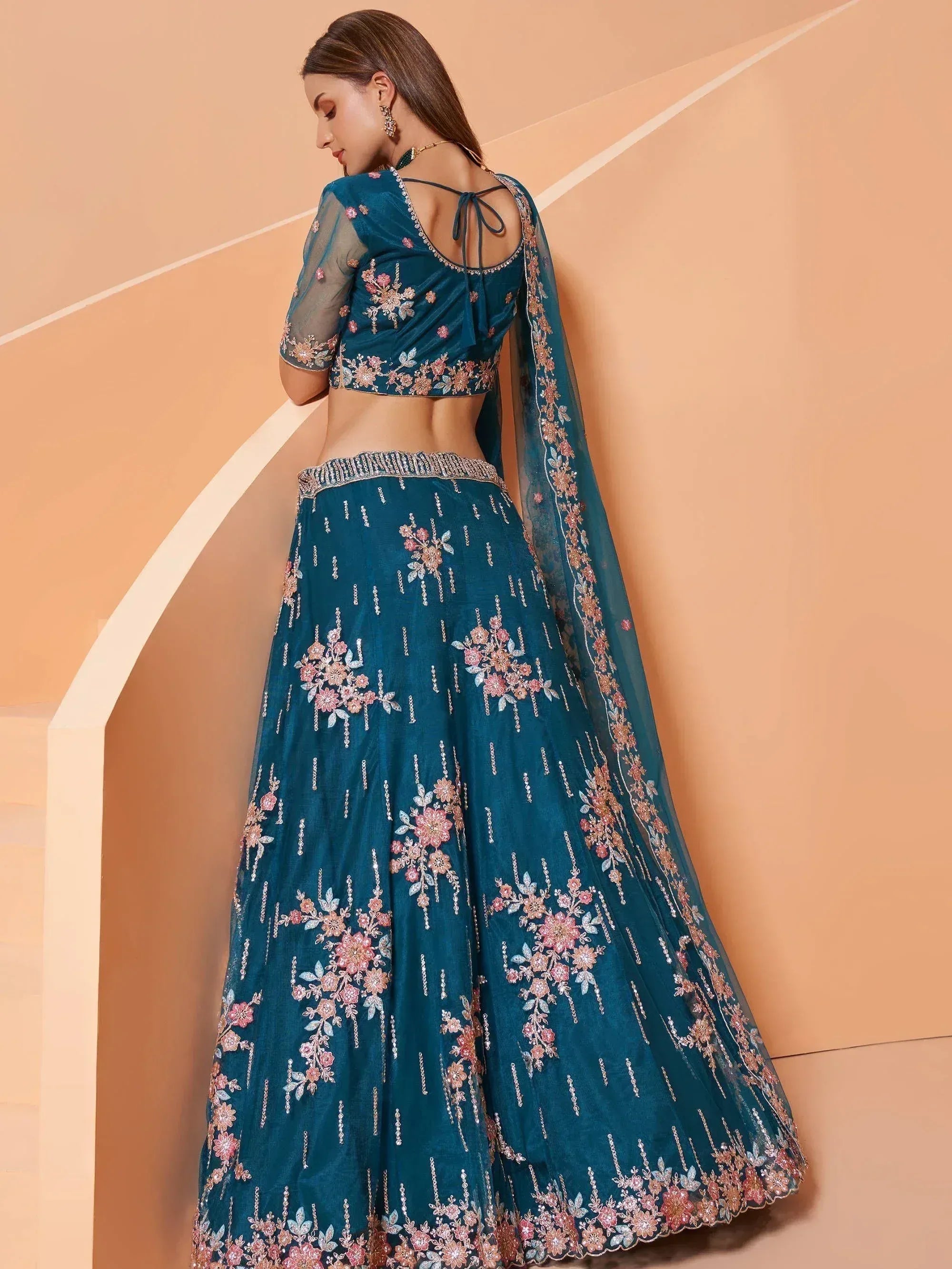 Teal floral embroidered lehenga choli with sheer sleeves and back tie, perfect for Indian ethnic occasions