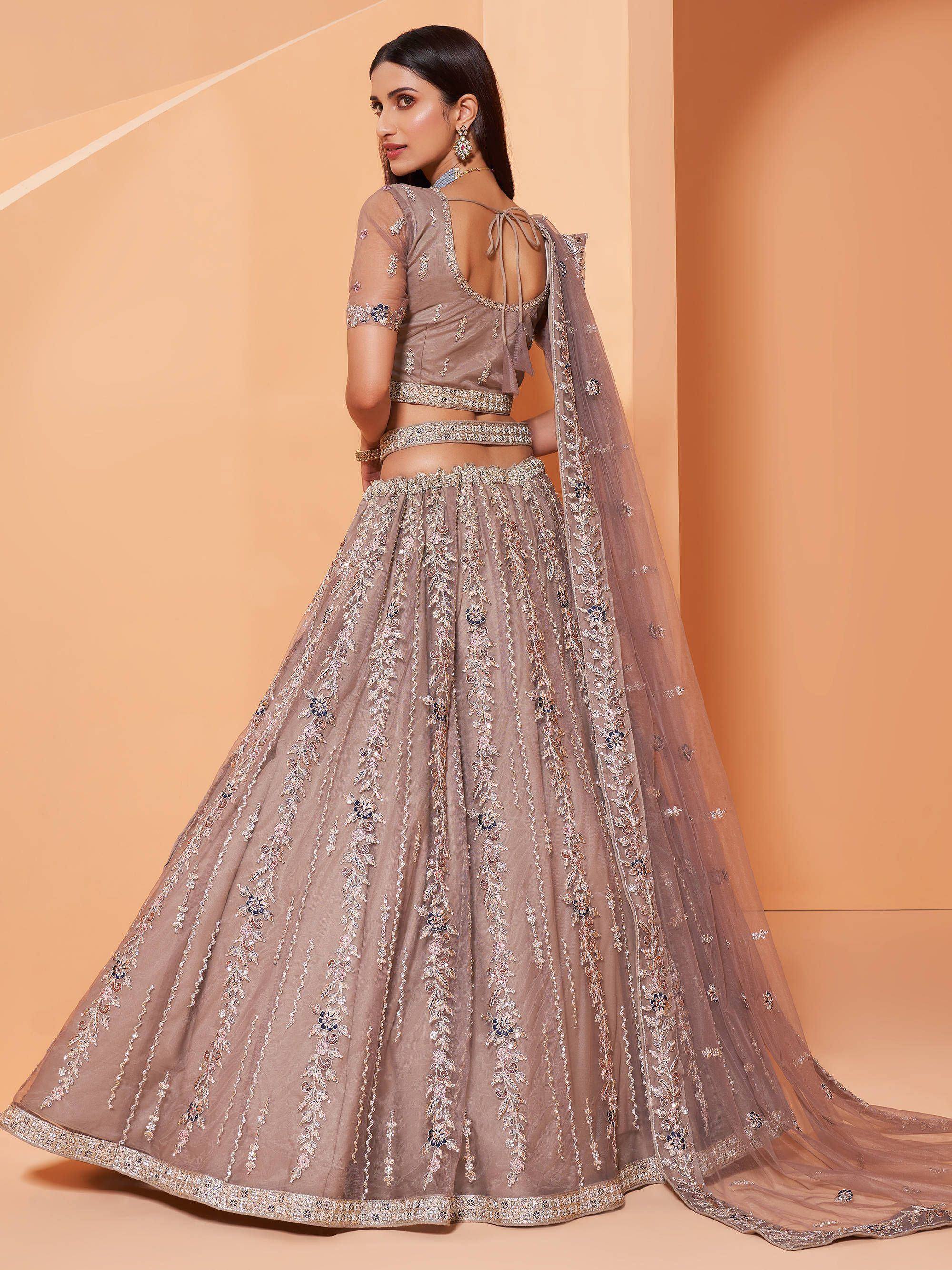Elegant beige lehenga choli with intricate floral embroidery and sheer dupatta, perfect for Indian weddings and festive occasions.