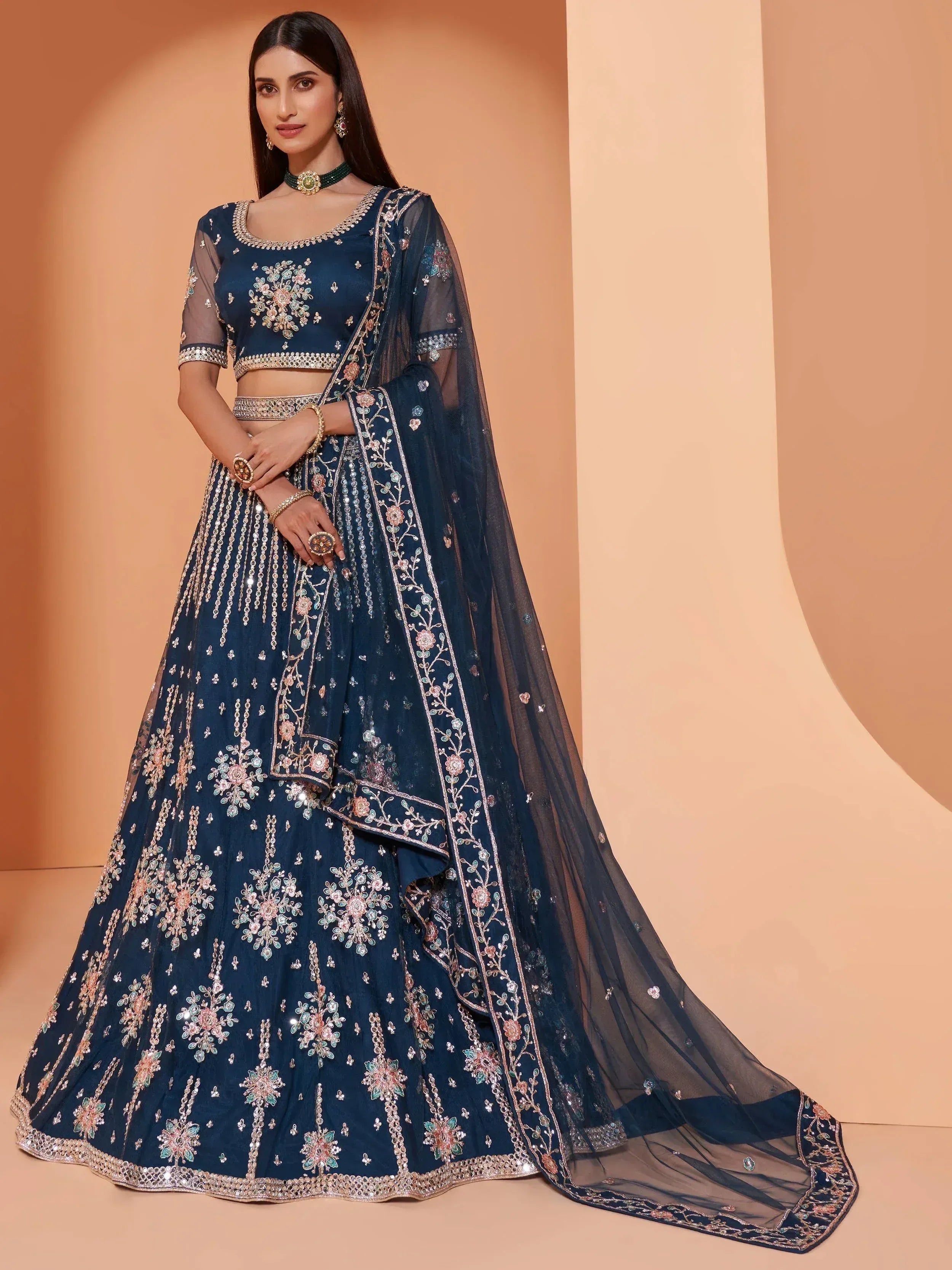 Elegant navy blue lehenga choli with floral embroidery and sheer dupatta, perfect for Indian weddings and festive occasions.