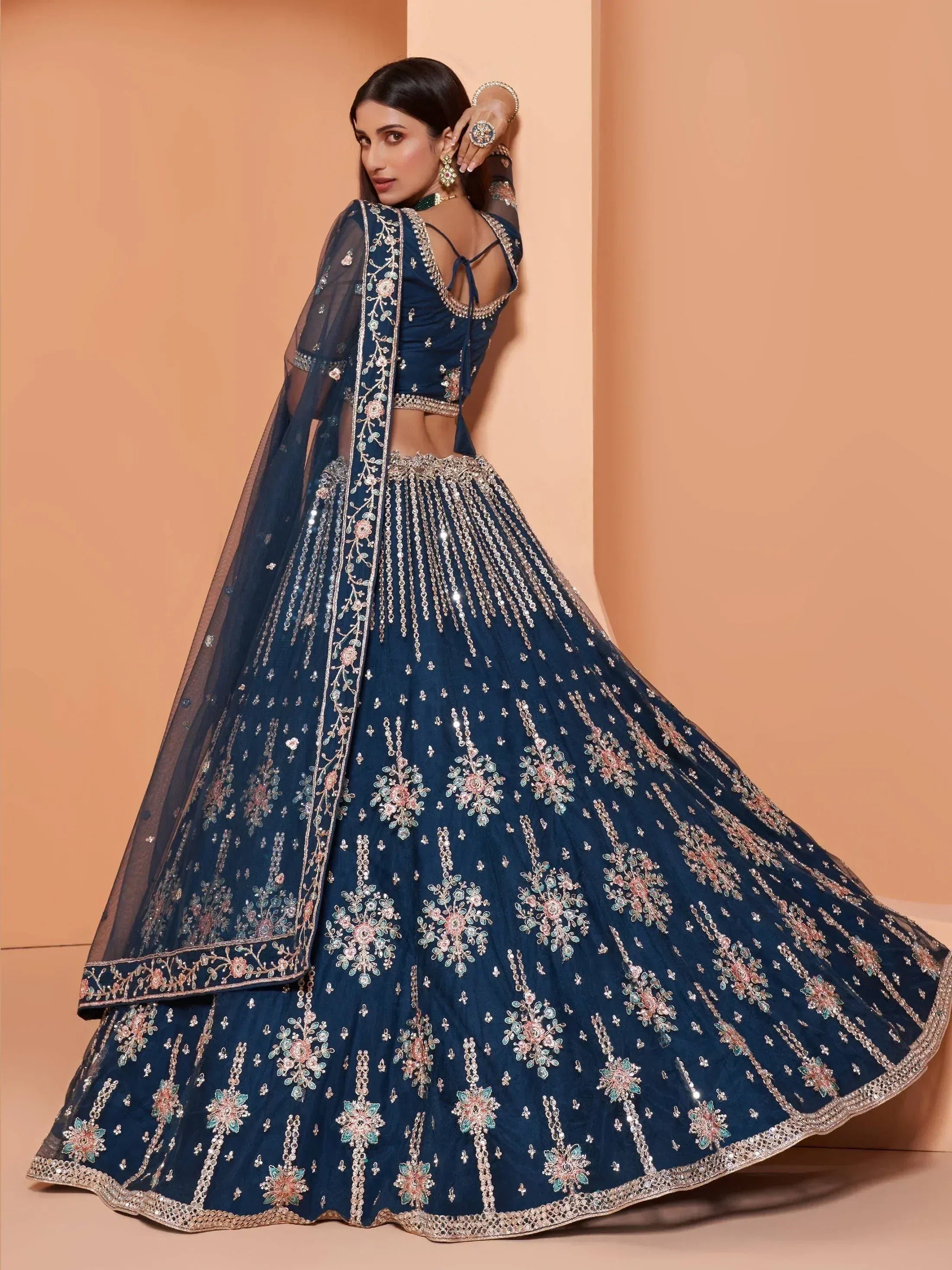 Elegant navy blue designer lehenga choli with floral embroidery and sequin detailing, perfect for weddings and festive occasions.