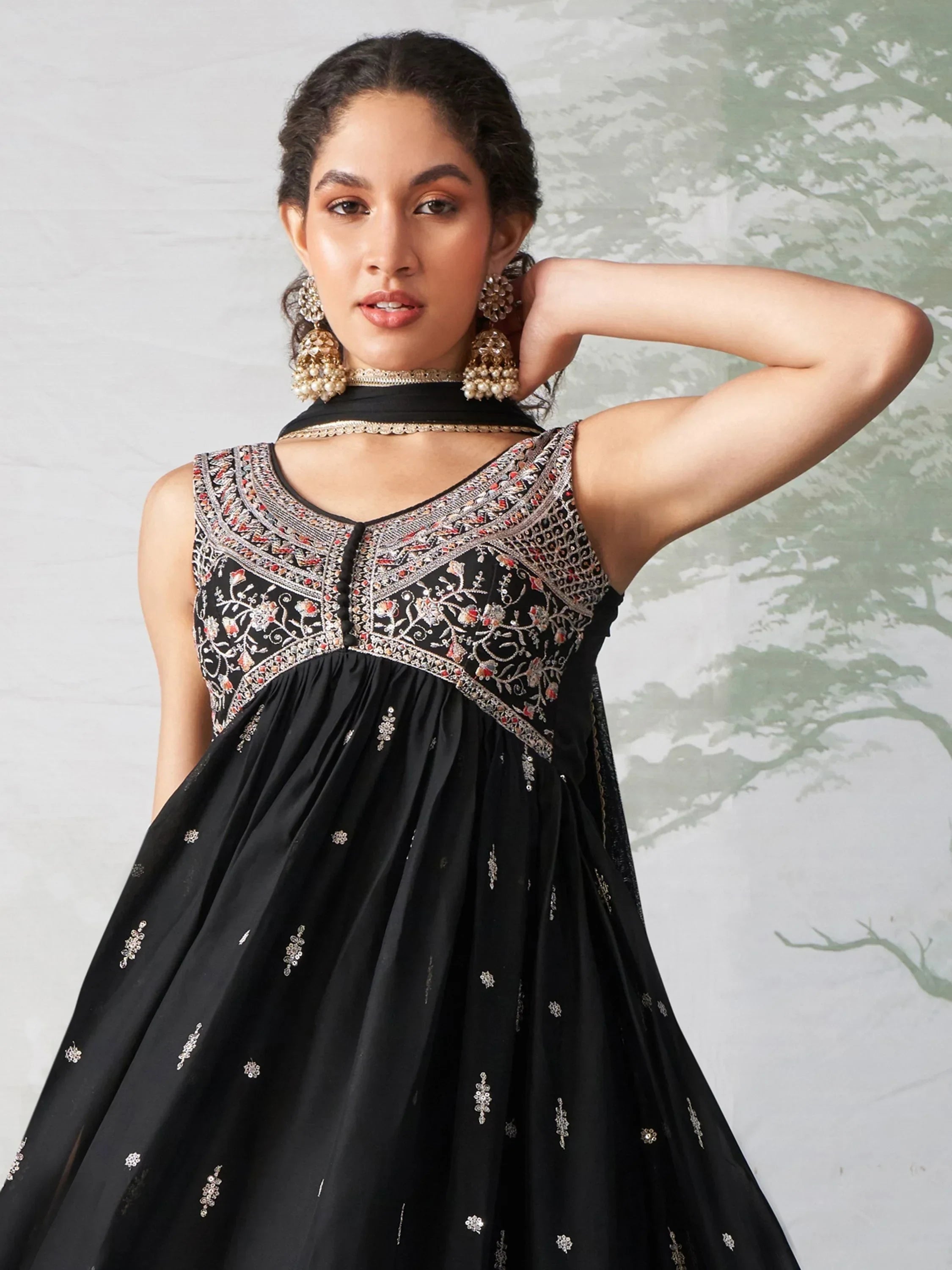Woman wearing black embroidered sleeveless ethnic gown with traditional jewelry