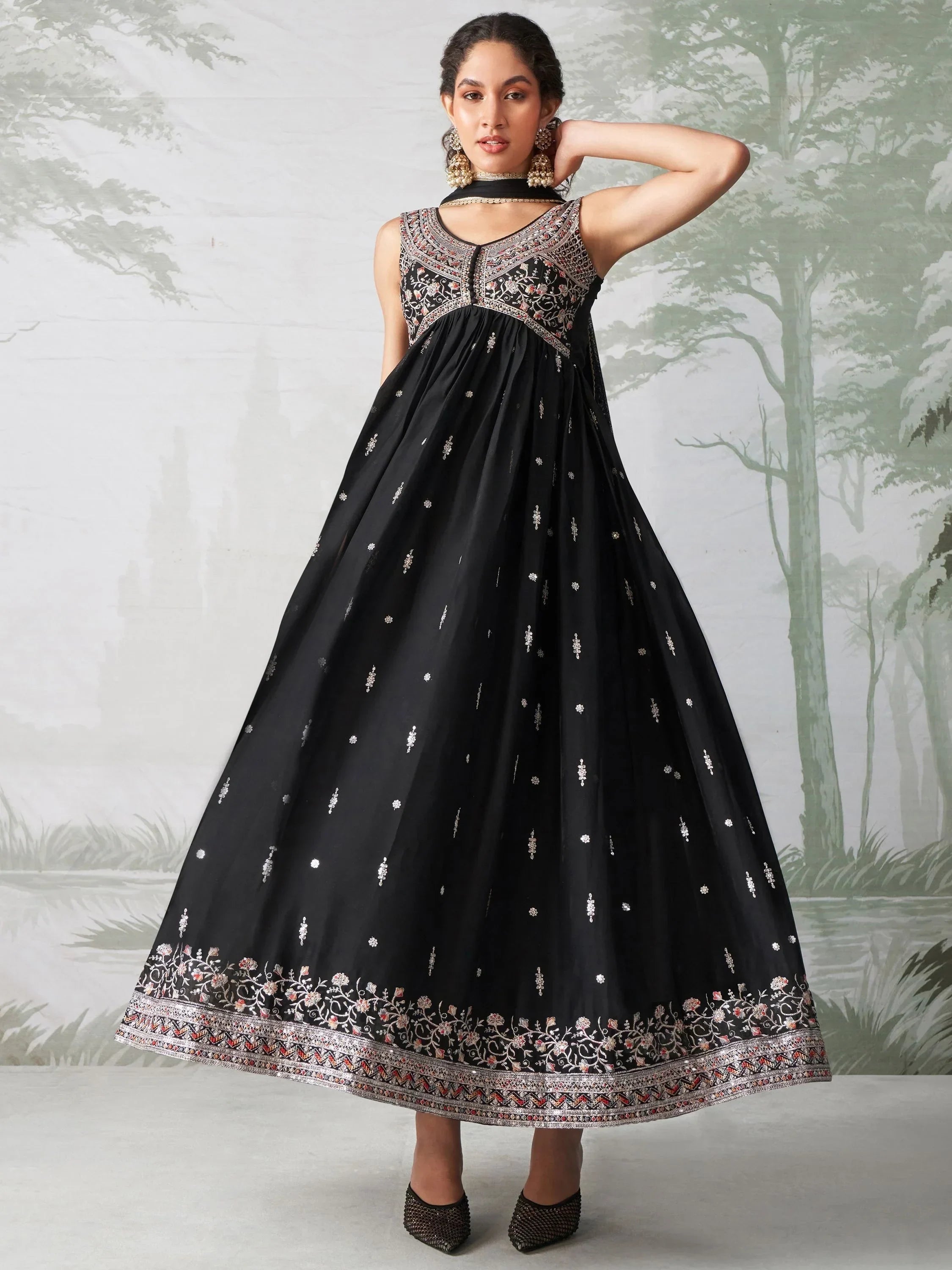 Woman wearing black embroidered Anarkali gown with ornate neckline and floral border