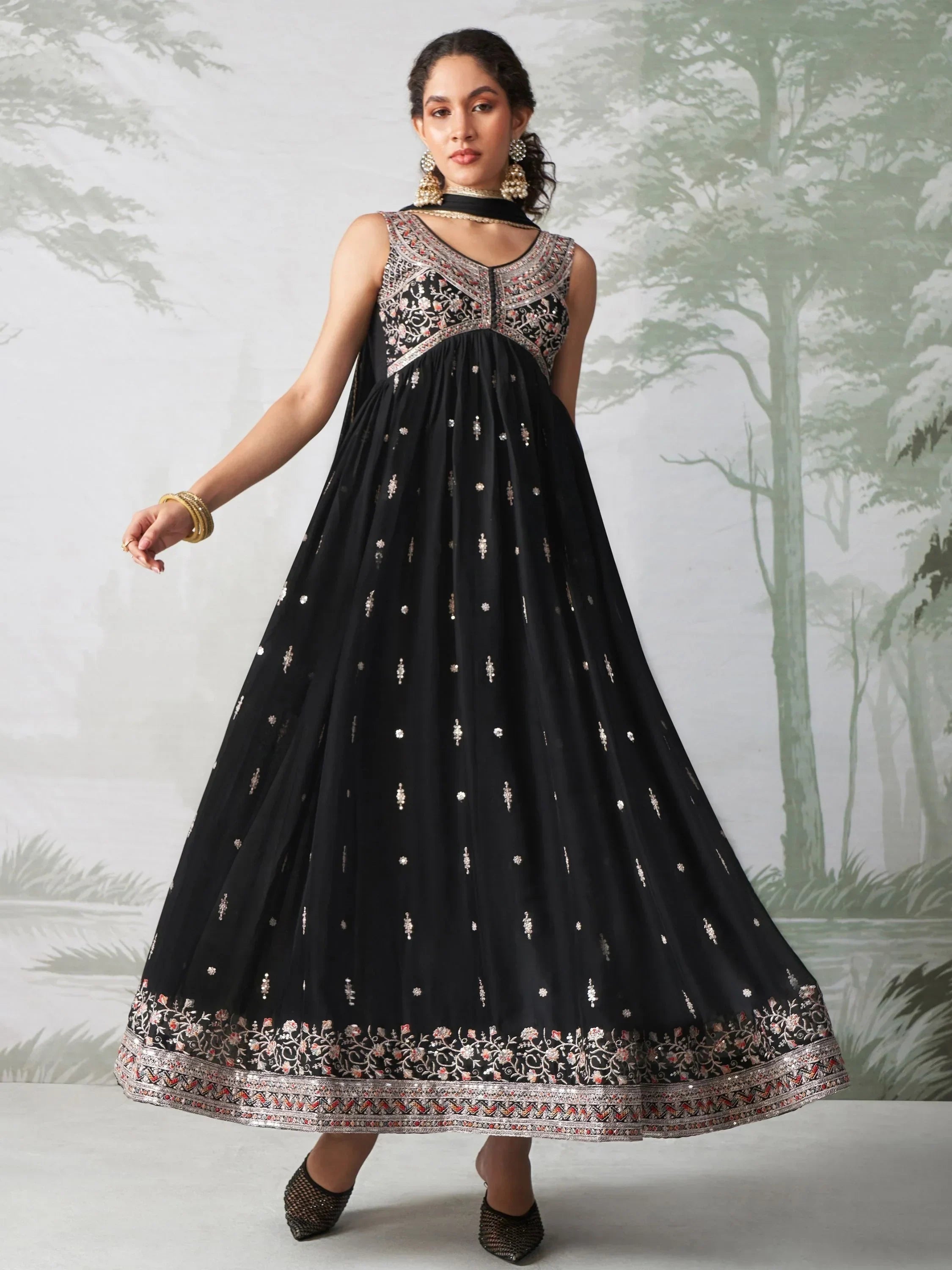 Woman in sleeveless black embroidered Anarkali dress with gold and silver detailing