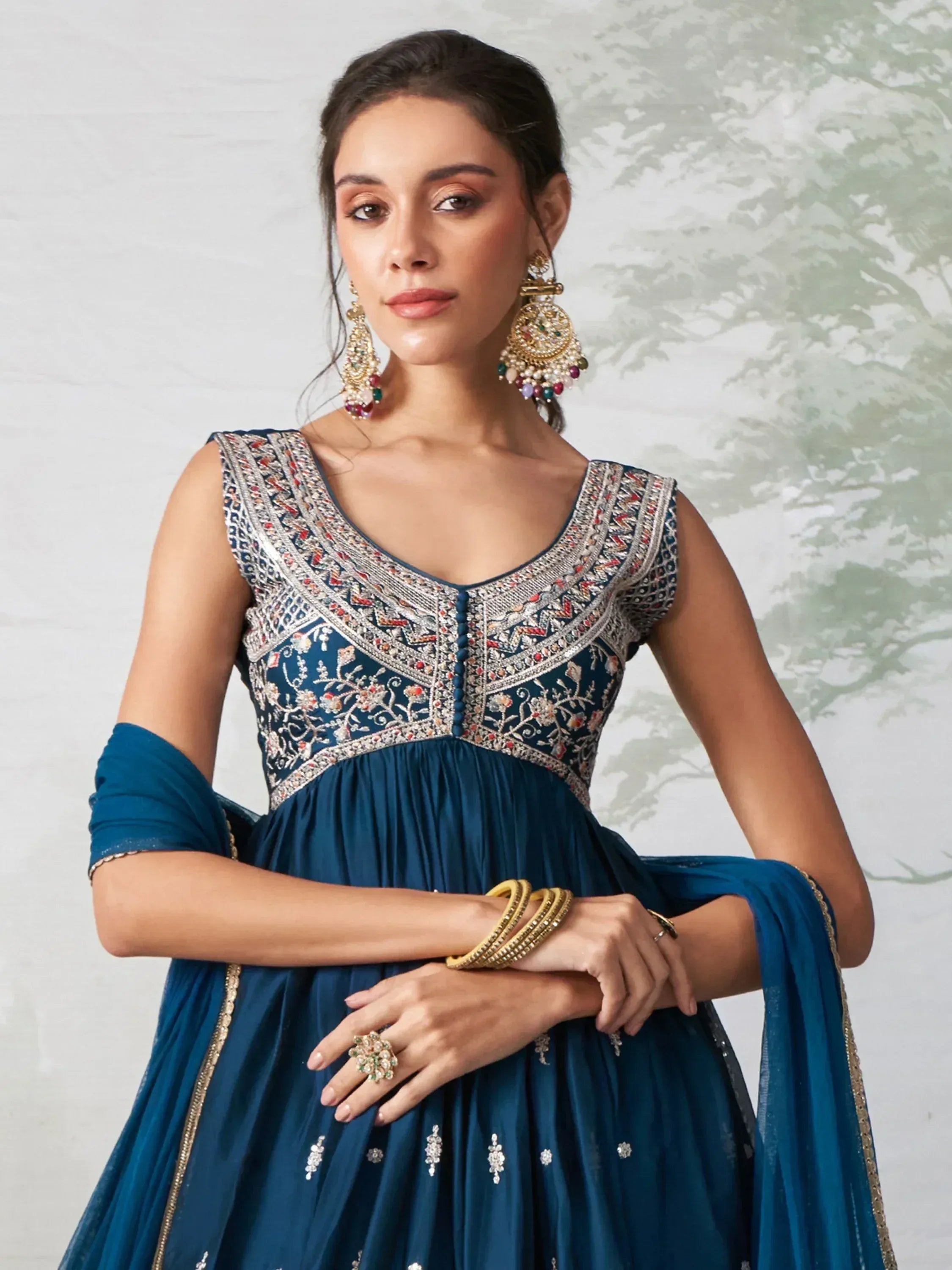 Blue embroidered Indian anarkali gown with gold jewelry, perfect for weddings and festive occasions