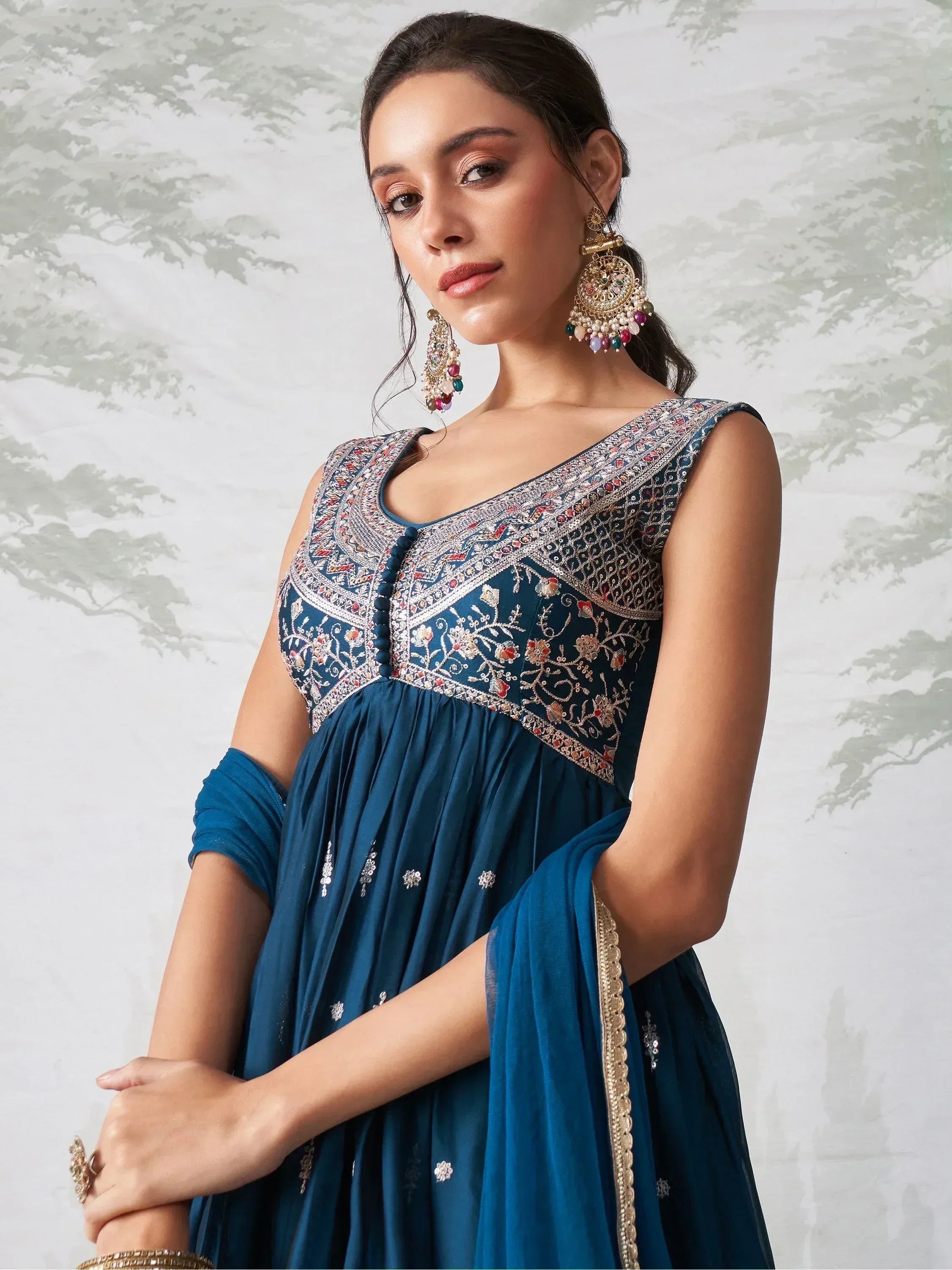 Blue embroidered ethnic gown with floral detailing and statement earrings