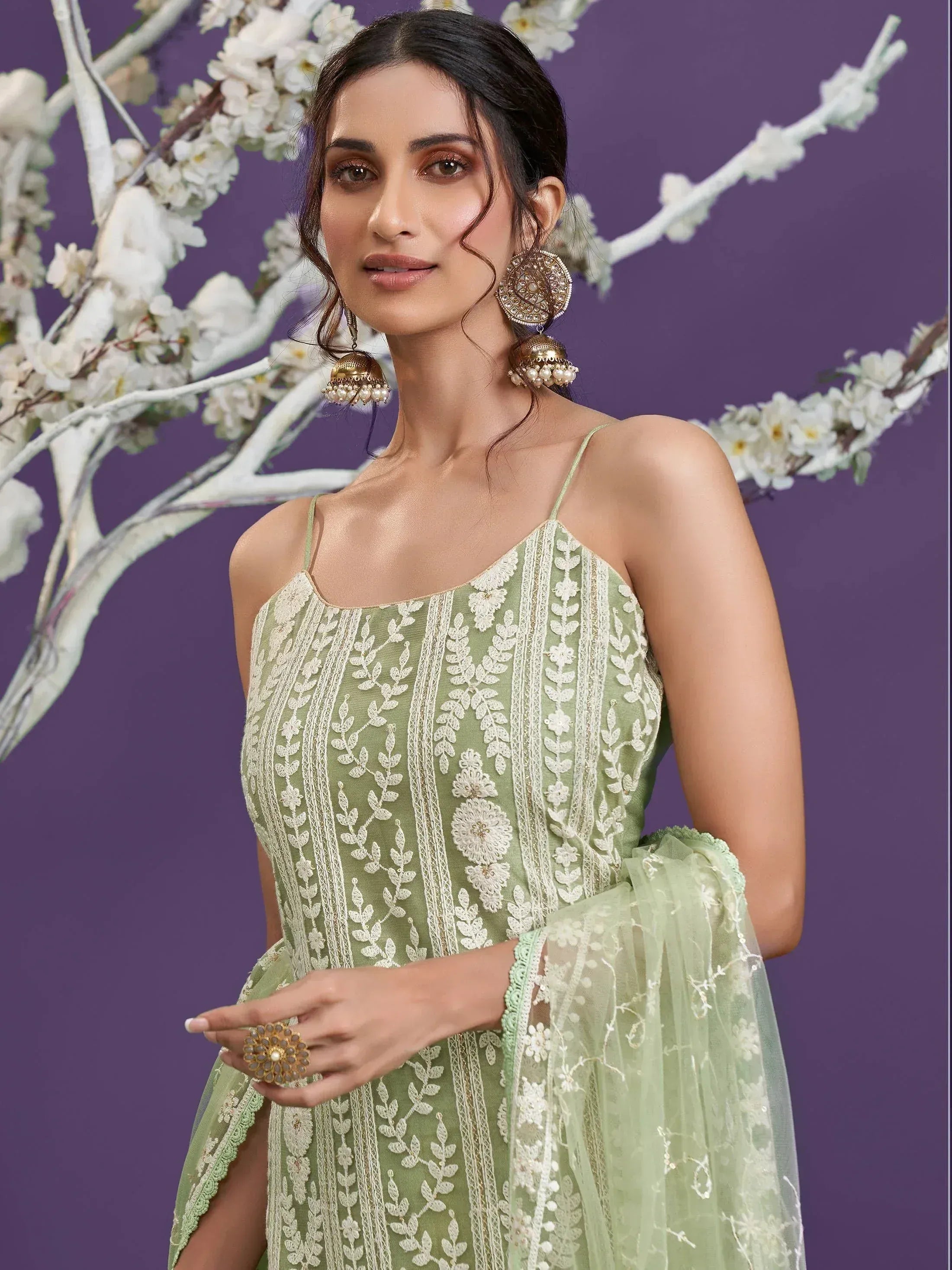 Elegant green embroidered ethnic gown with floral detailing and jhumka earrings