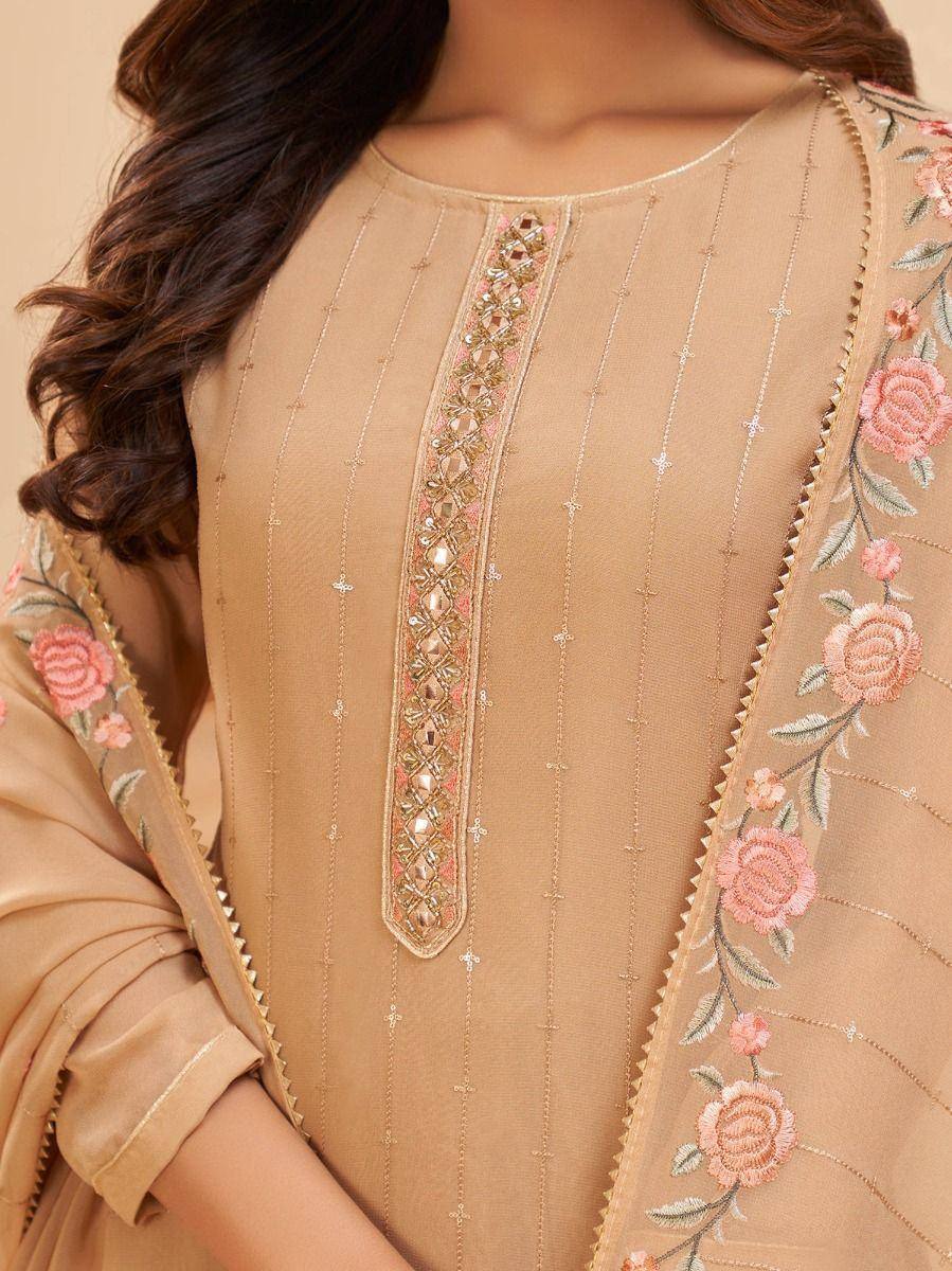 Beige embroidered salwar kameez with floral work and mirror detailing, perfect for ethnic occasions.