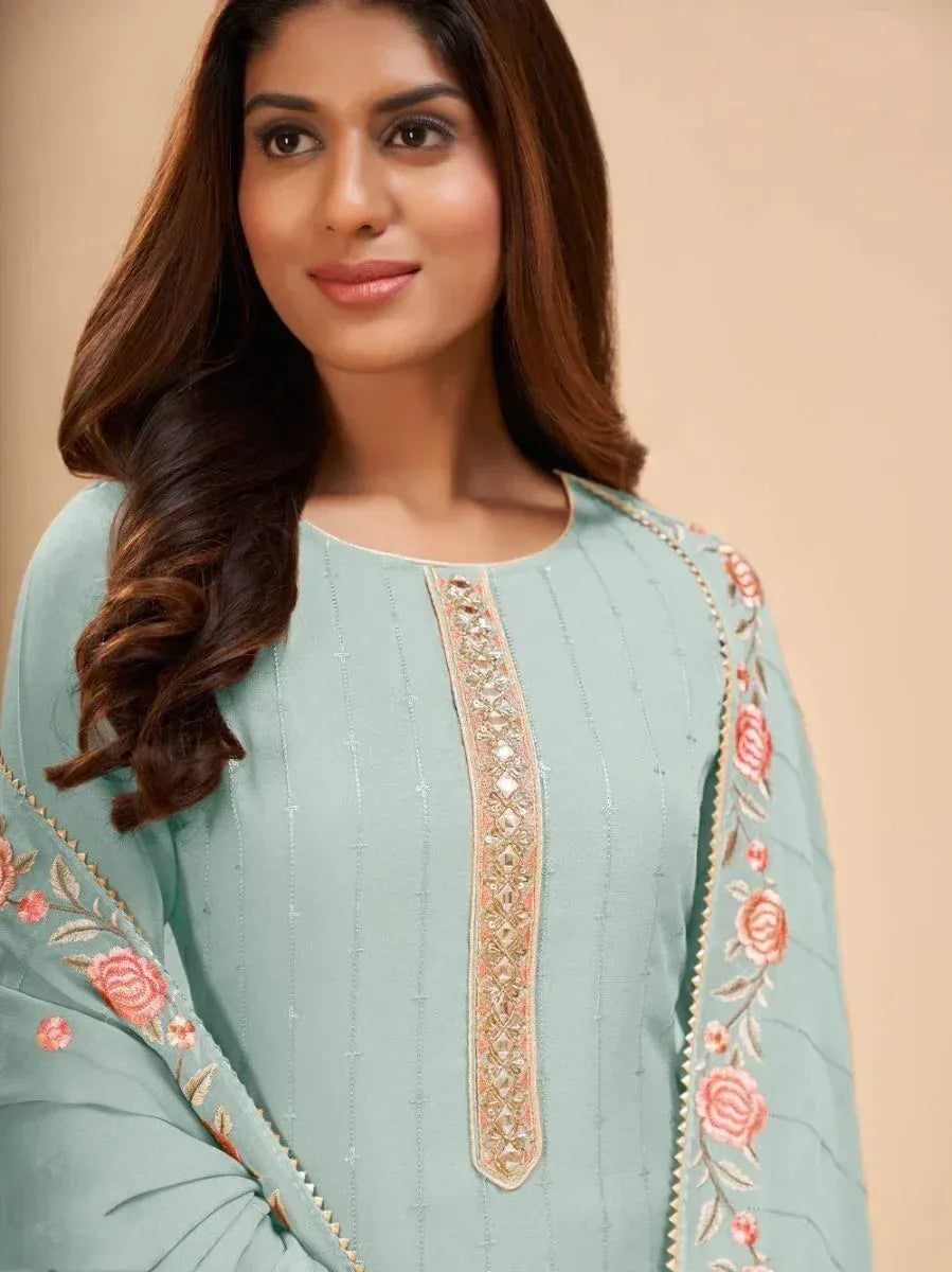 Woman wearing pastel blue embroidered salwar kameez with floral detailing