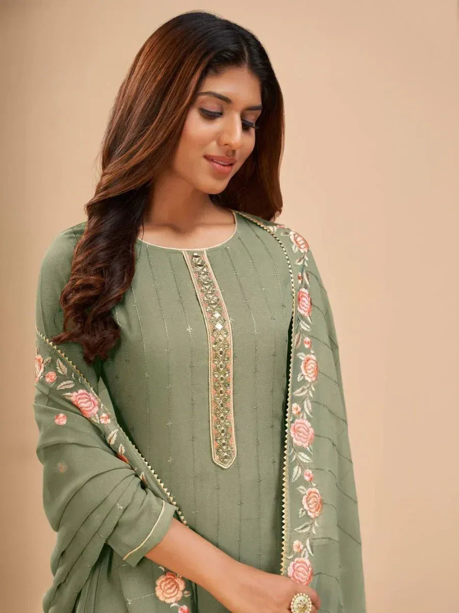 Woman wearing sage green embroidered salwar kameez with floral dupatta