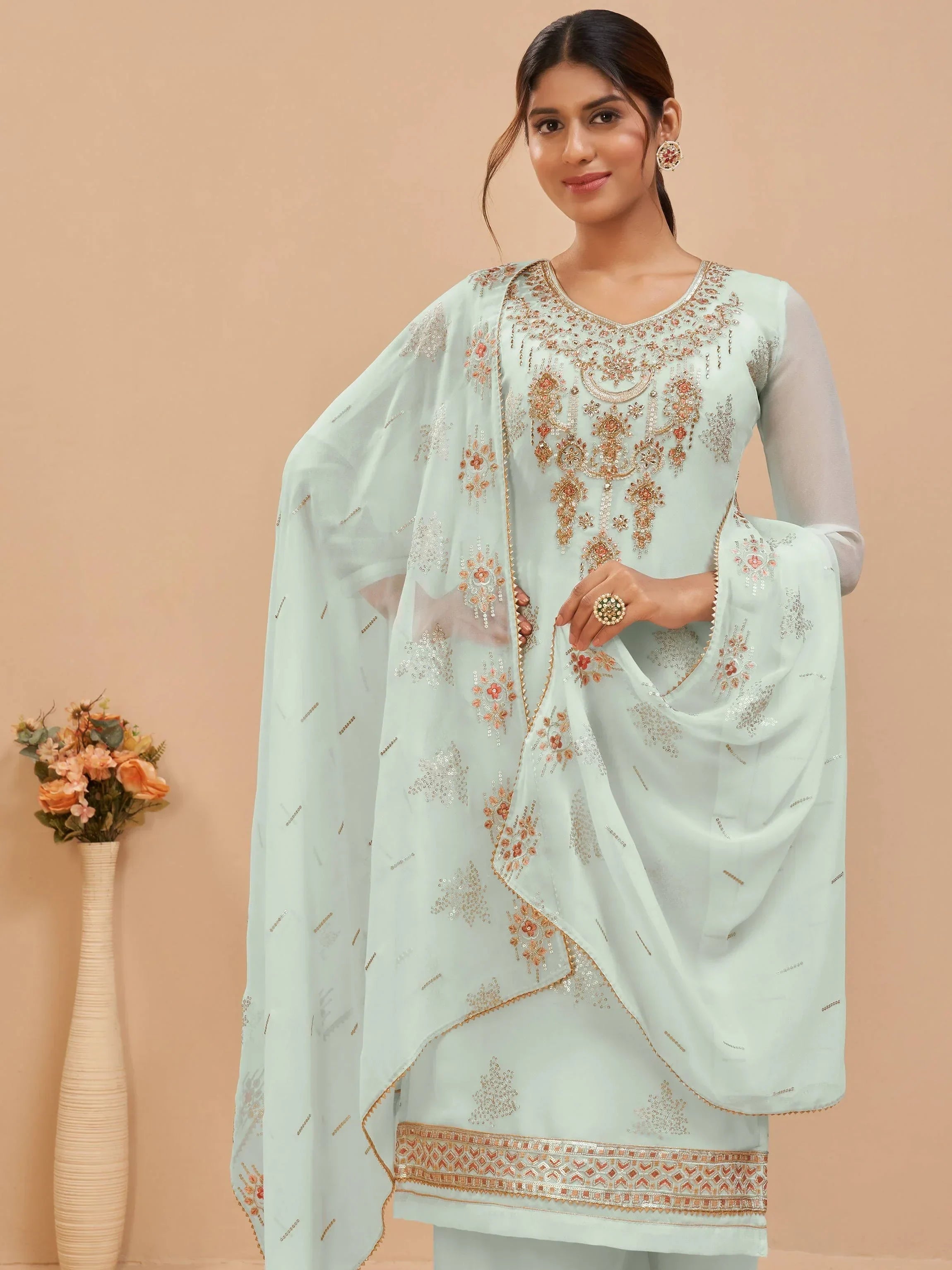 Woman wearing light blue embroidered salwar kameez with dupatta, floral design, ethnic wear