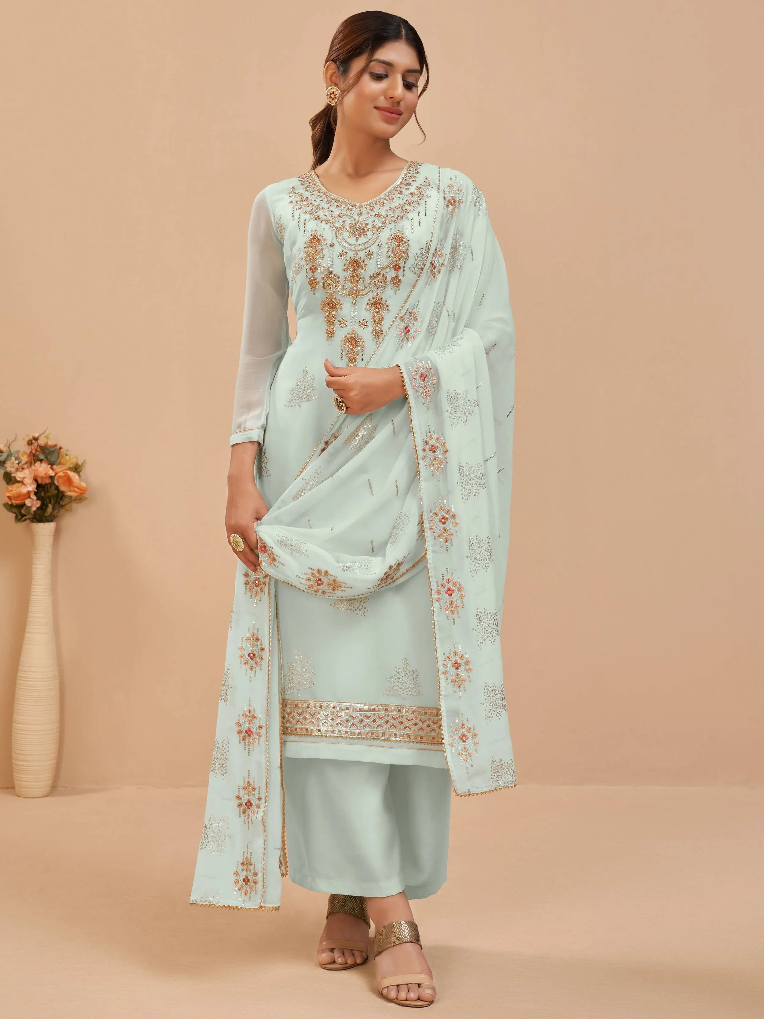 Woman in light blue embroidered salwar kameez with matching dupatta, ethnic wear style