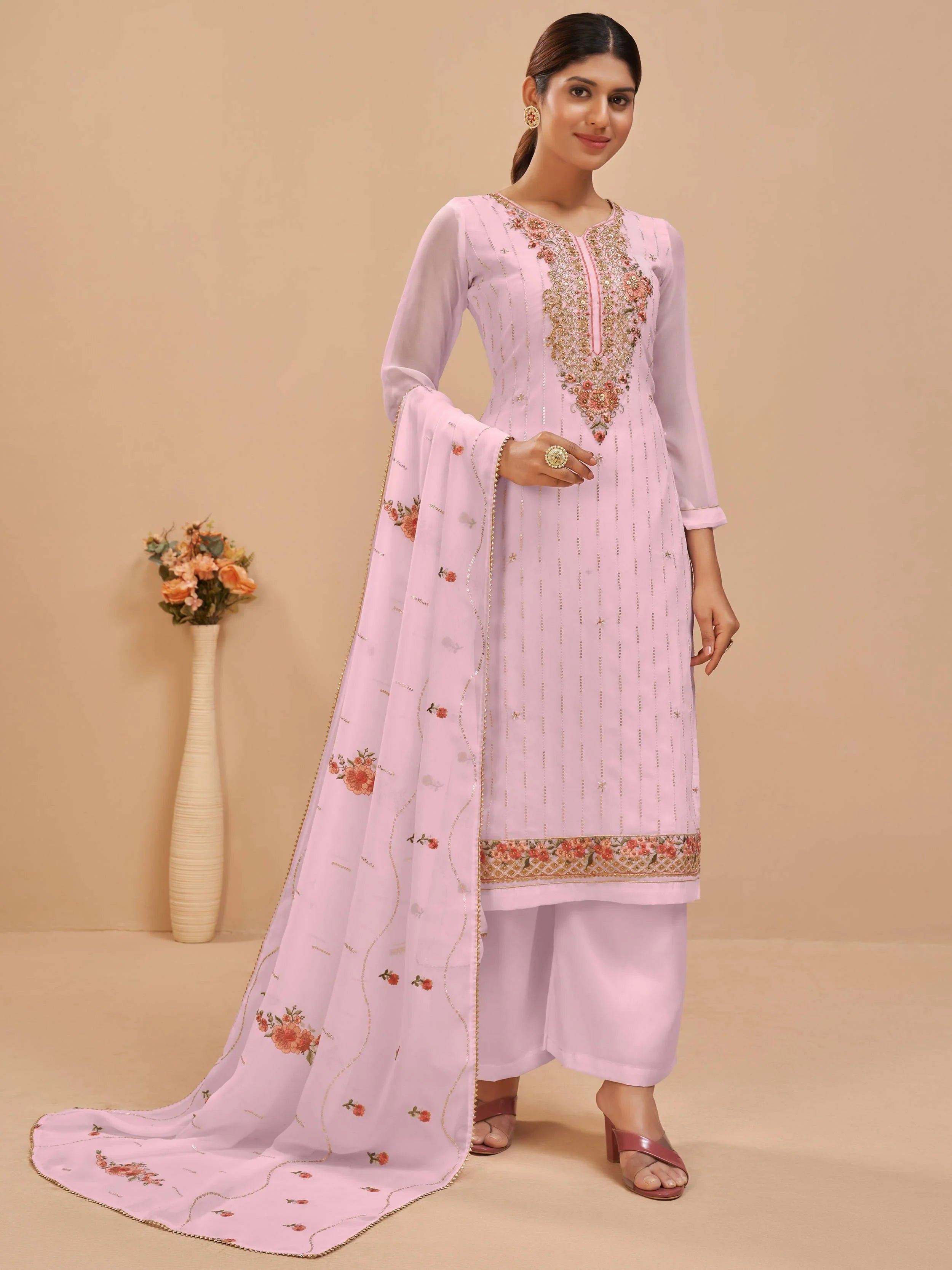 Woman wearing light pink embroidered salwar kameez with floral dupatta, ethnic wear
