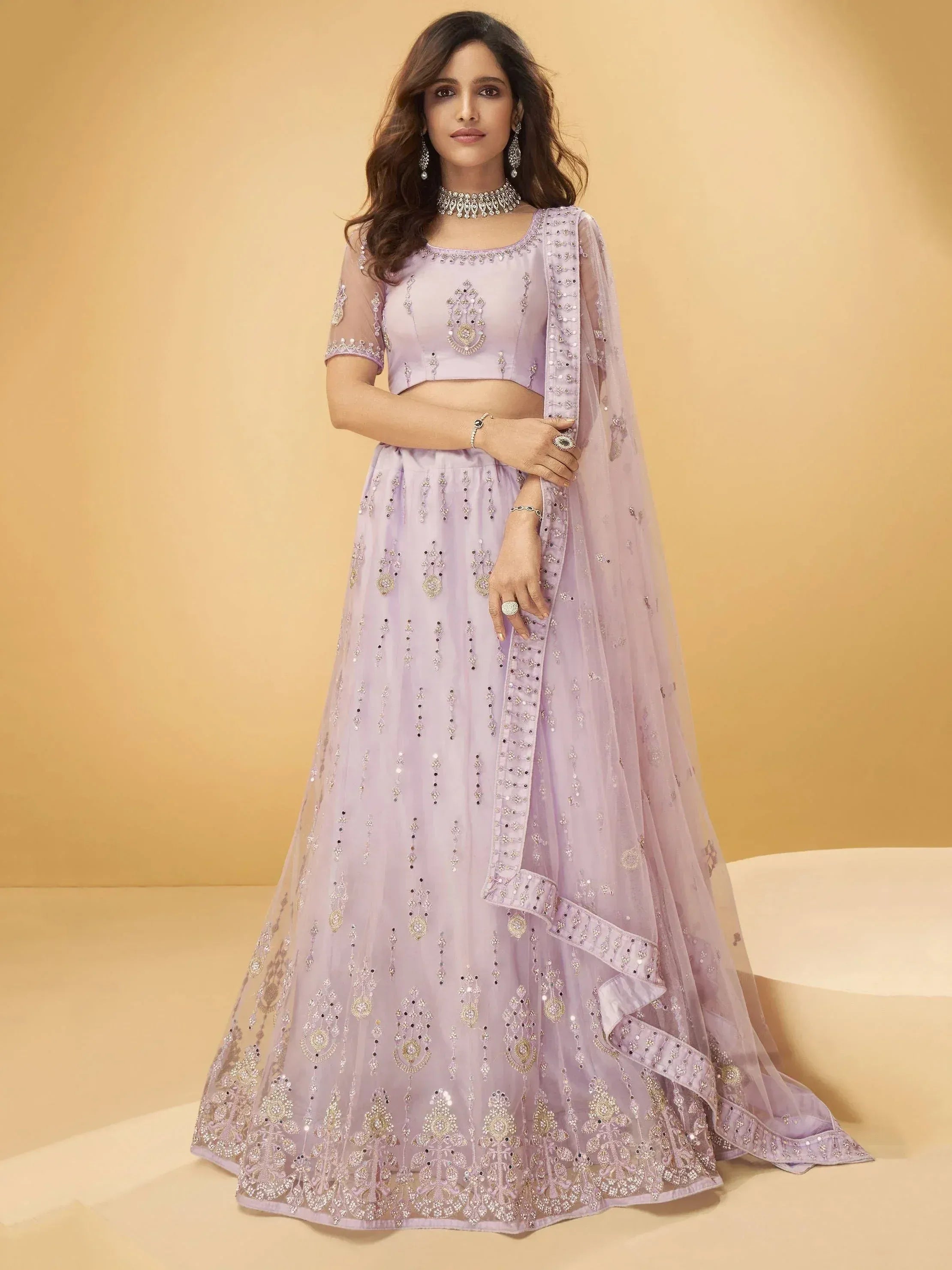 Lavender designer lehenga choli with heavy embroidery and sheer dupatta, perfect for Indian weddings and parties.