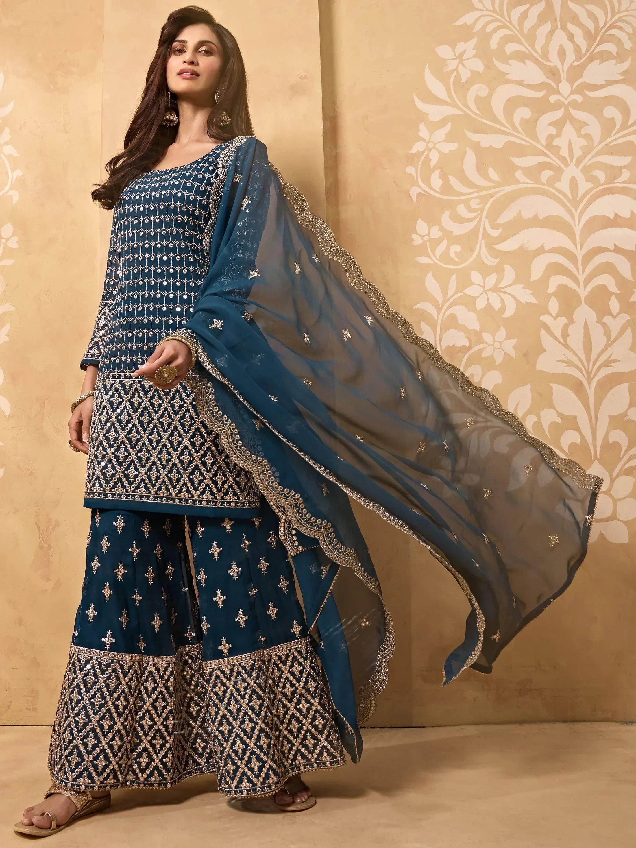 Woman wearing navy blue embroidered ethnic salwar kameez with dupatta, gold details