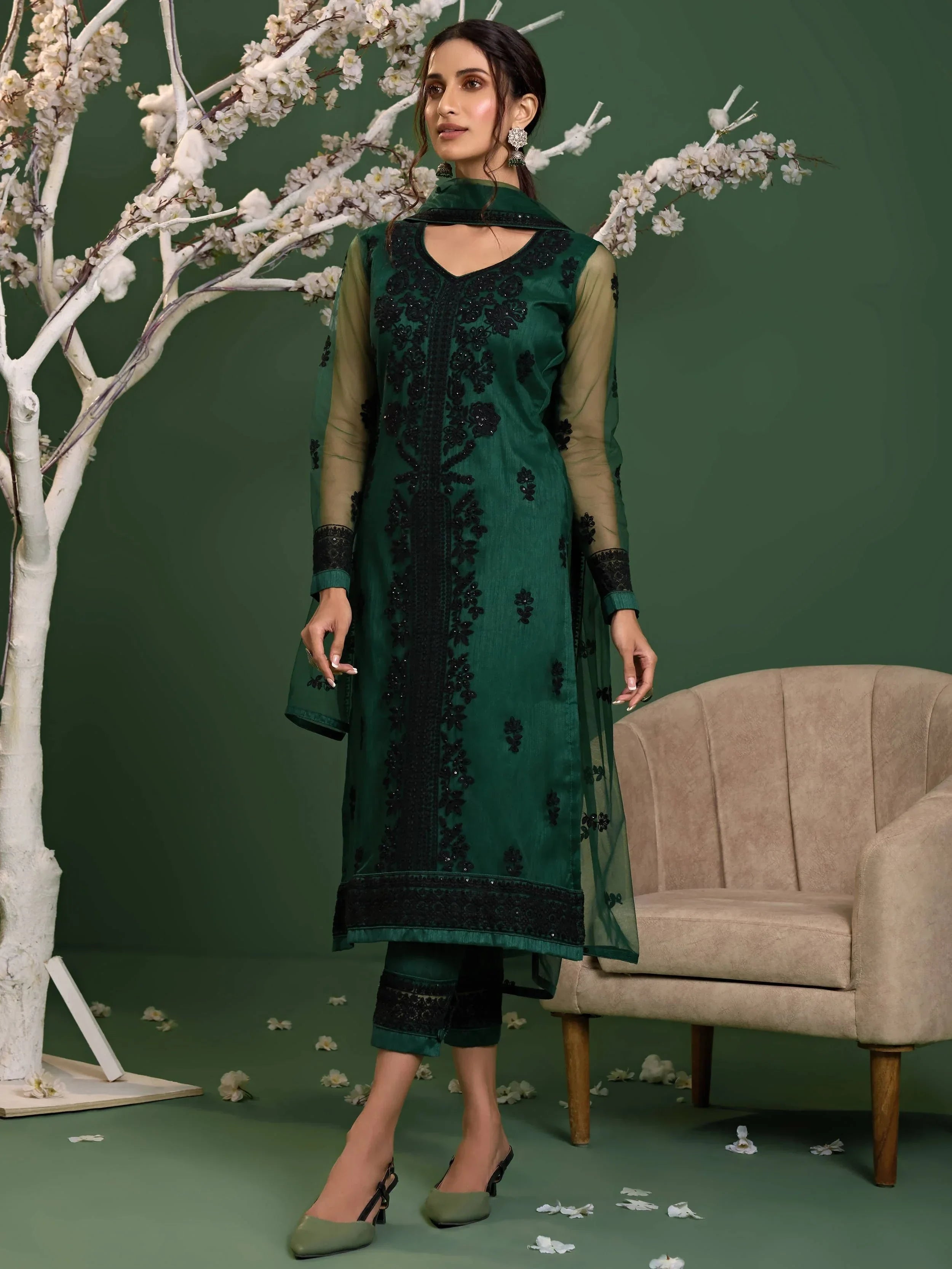Woman in dark green embroidered salwar kameez with matching dupatta and straight pants