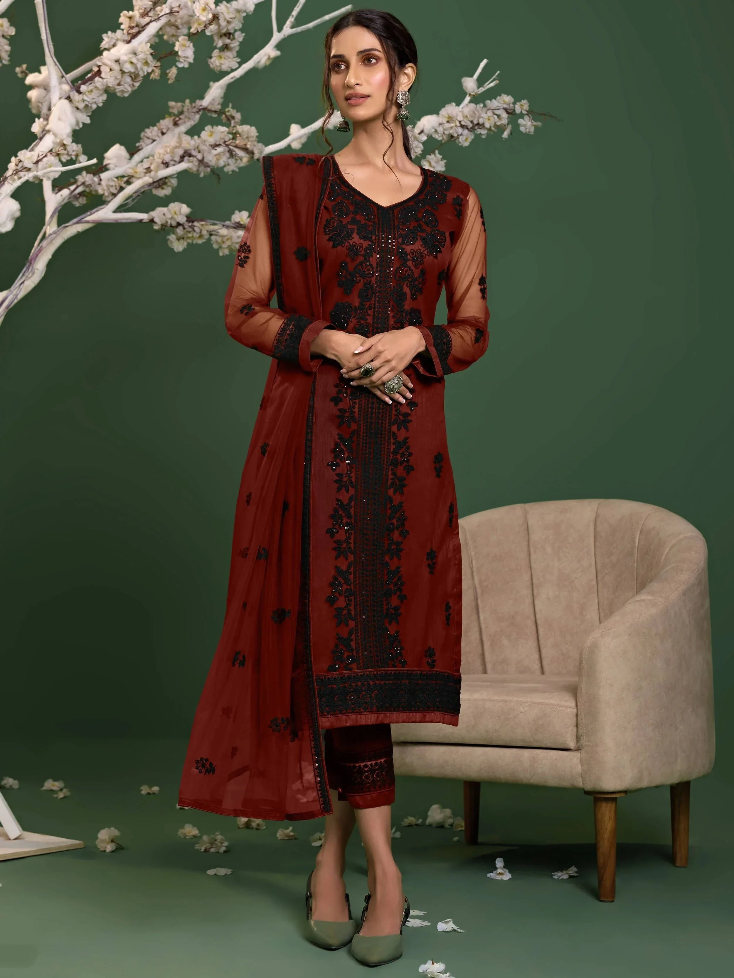 Woman wearing maroon embroidered salwar kameez set with dupatta, standing indoors