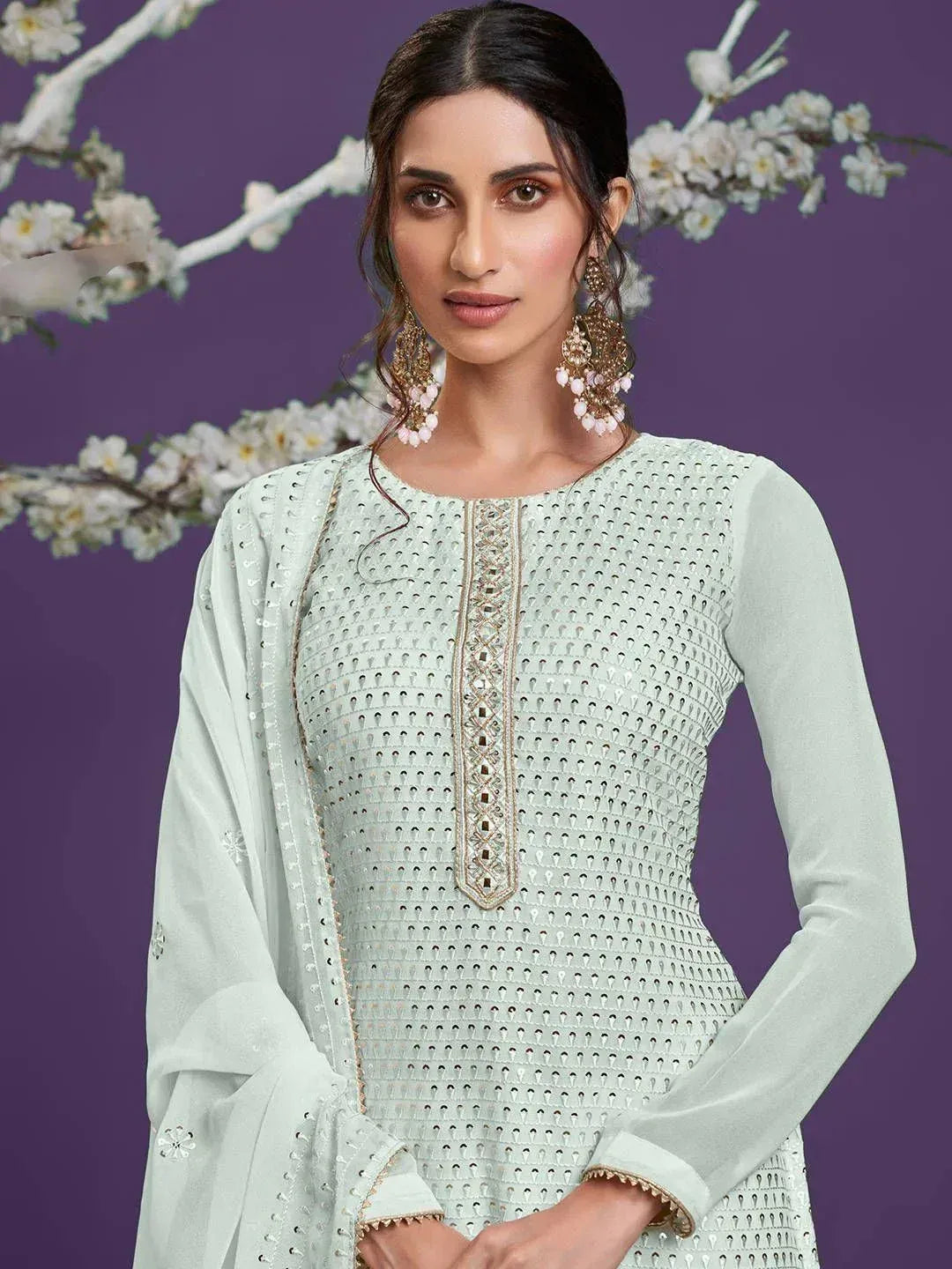 Mint green embroidered kurti with sheer sleeves and floral backdrop, perfect for ethnic occasions