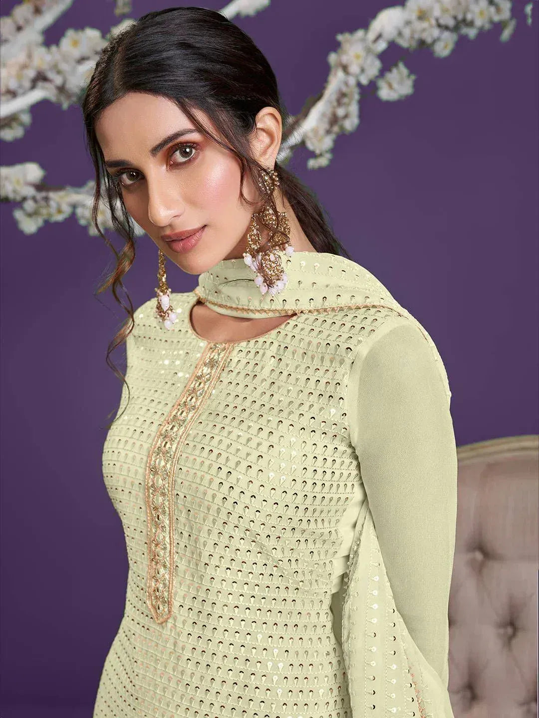 Elegant light green ethnic gown with intricate embroidery and mirror work, perfect for Indian festivities.