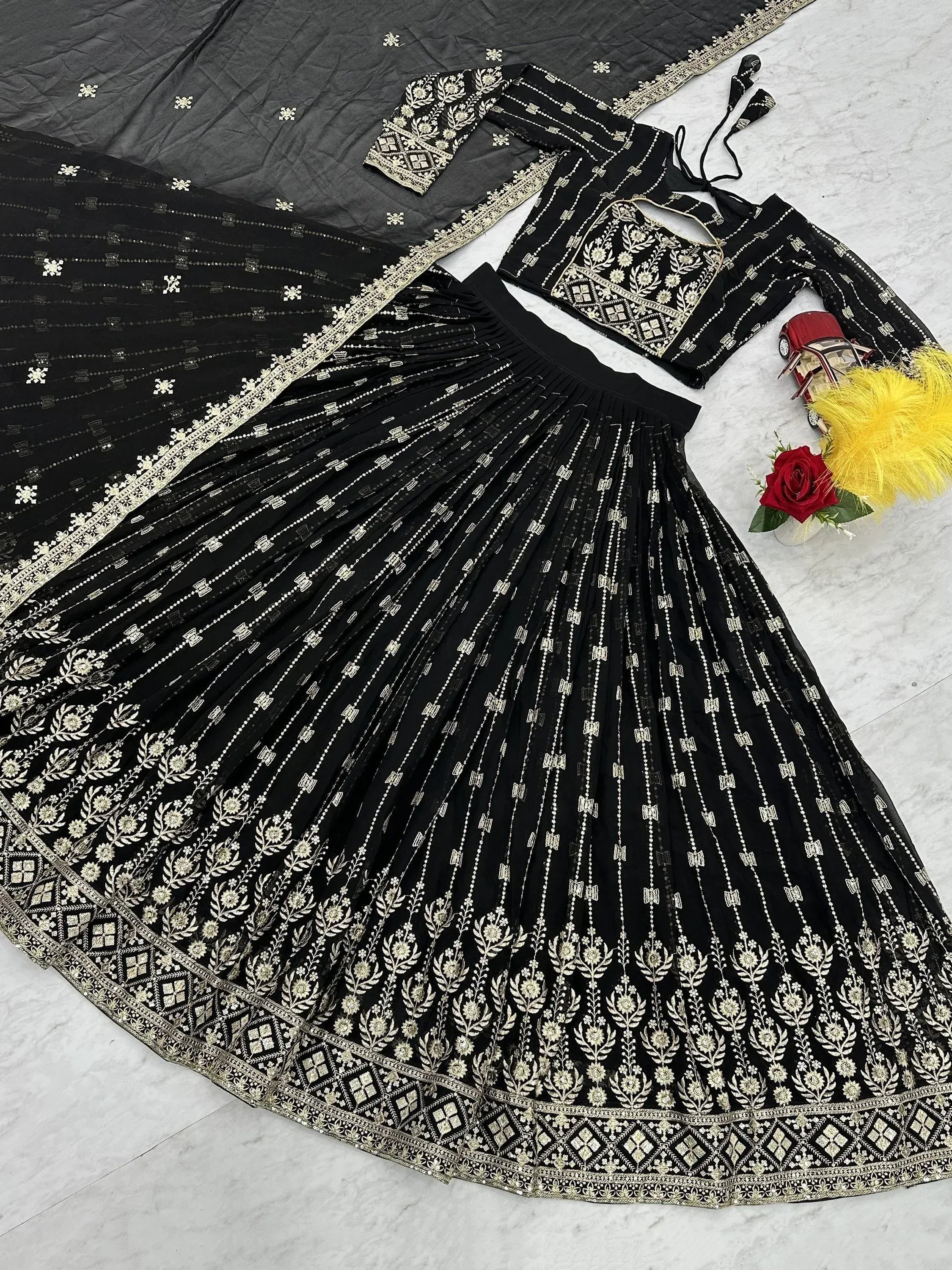 Black designer lehenga choli with gold embroidery, pleated skirt, and matching dupatta for Indian ethnic wear