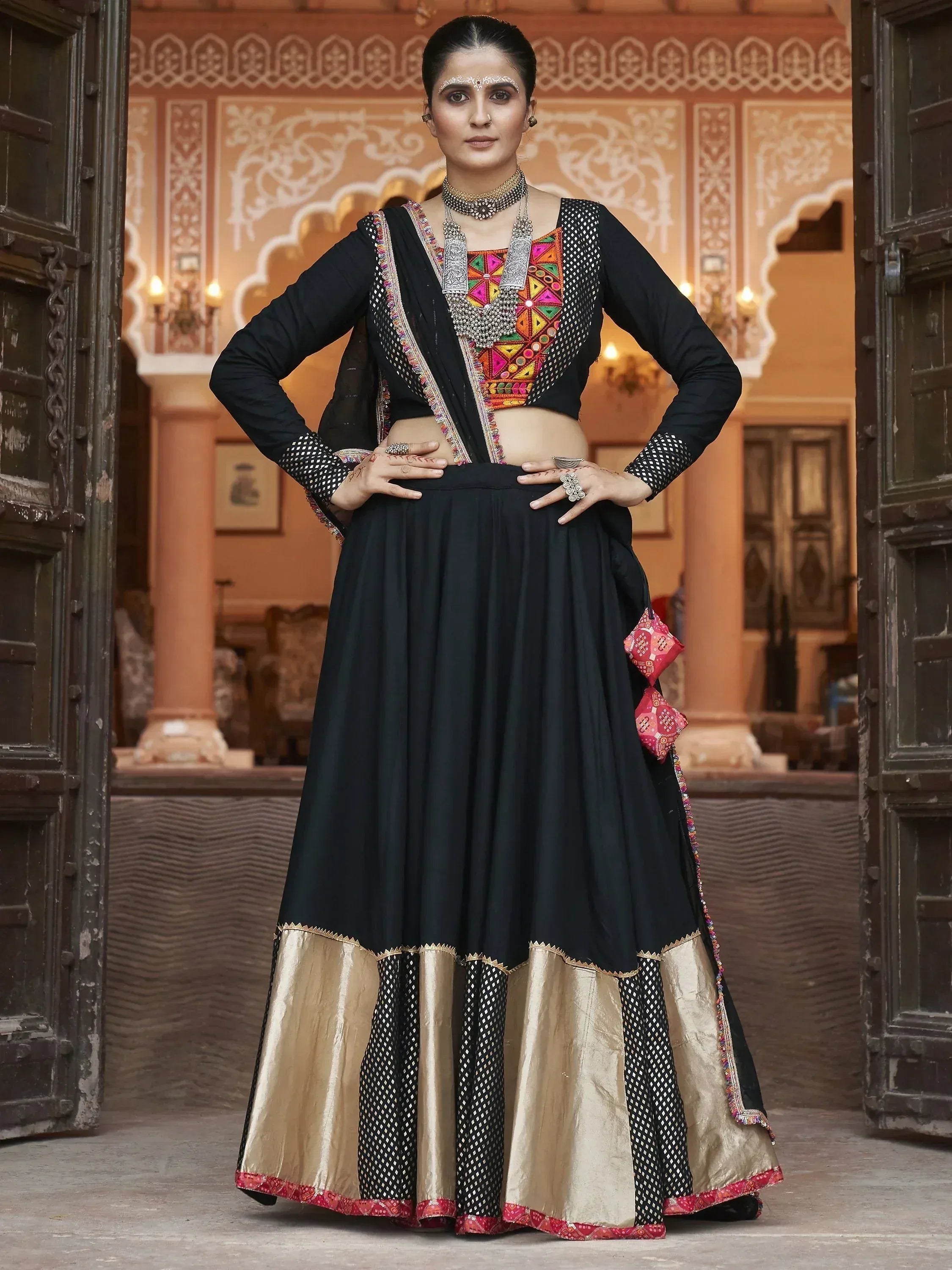 Black and gold ethnic lehenga with colorful embroidery, perfect for Indian weddings and festive occasions.