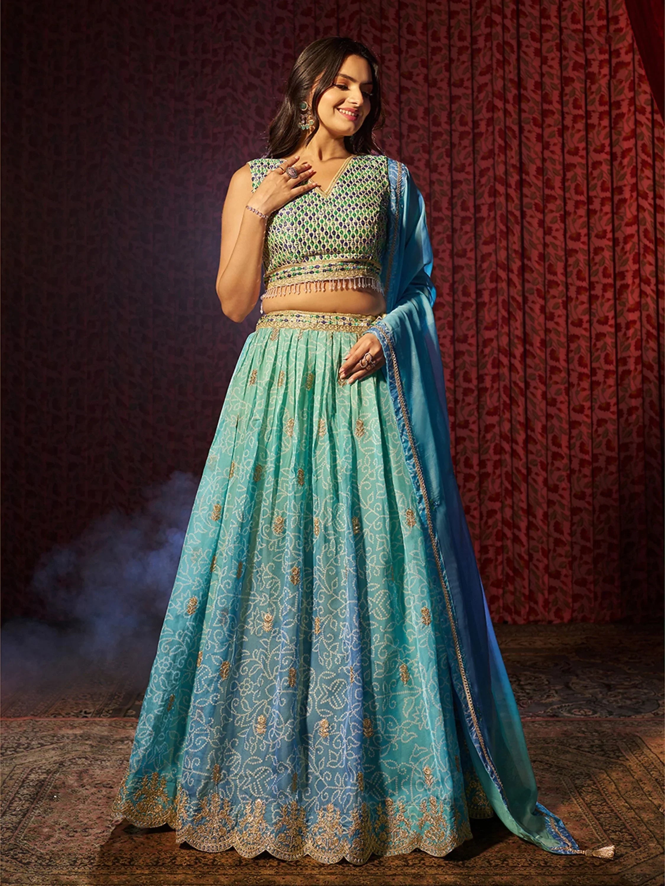 Turquoise embroidered lehenga choli with green and gold detailing, perfect for Indian ethnic wear events.