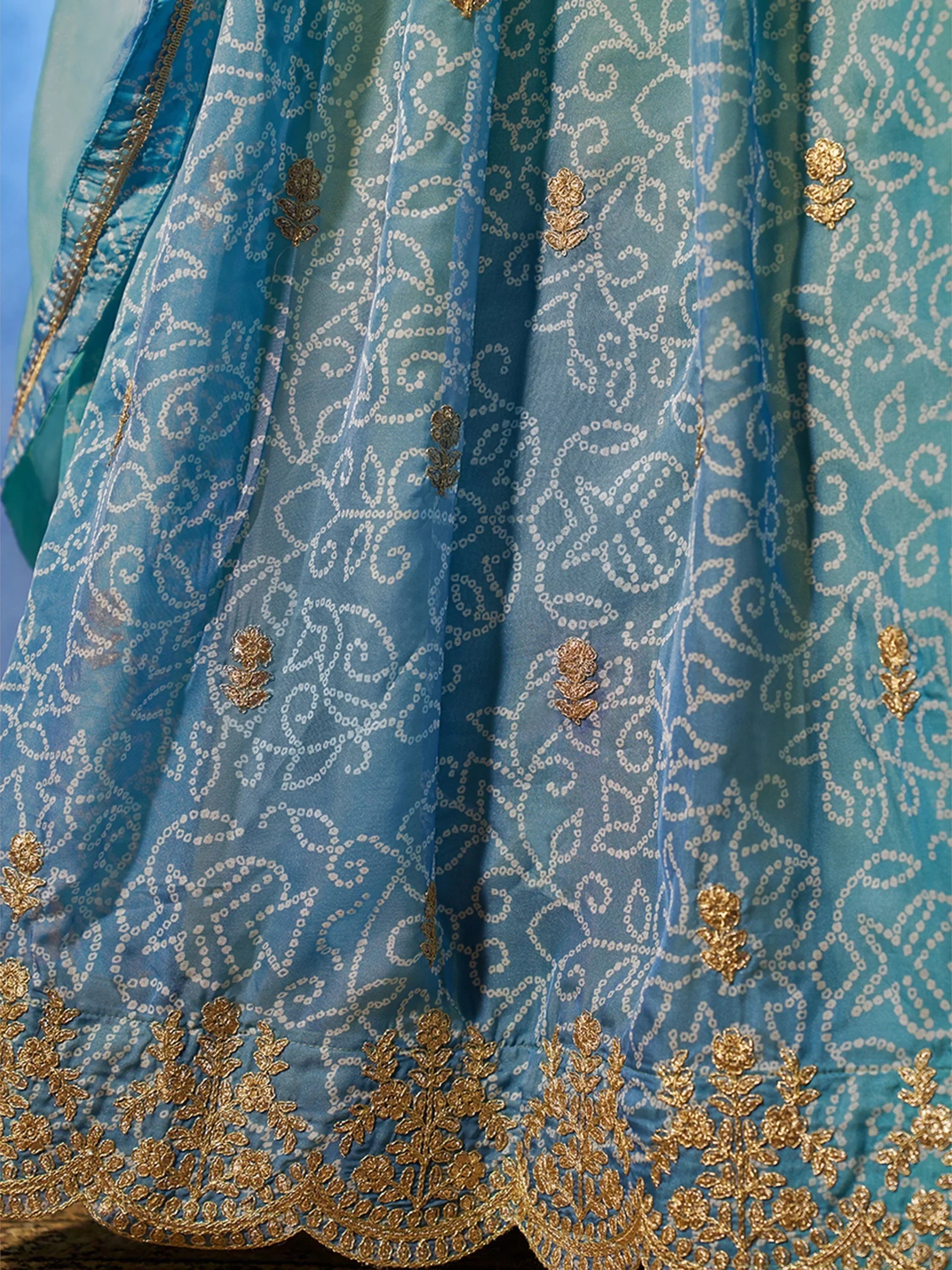 Blue Indian ethnic lehenga with gold floral embroidery and intricate white patterns