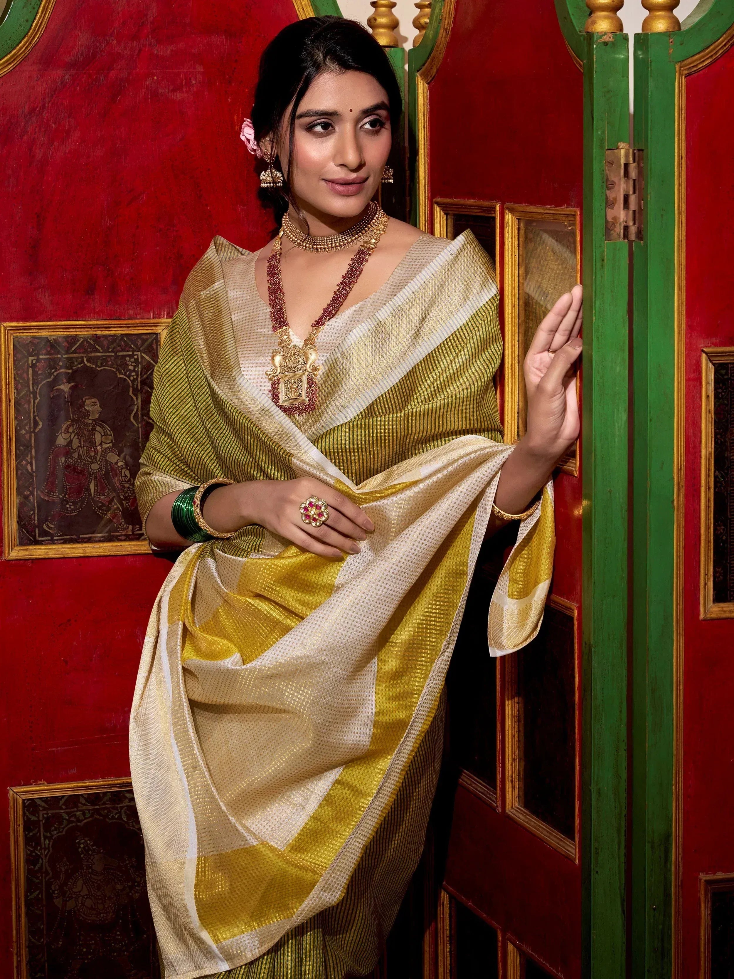 Woman in elegant yellow and white saree with gold jewelry, traditional Indian ethnic wear