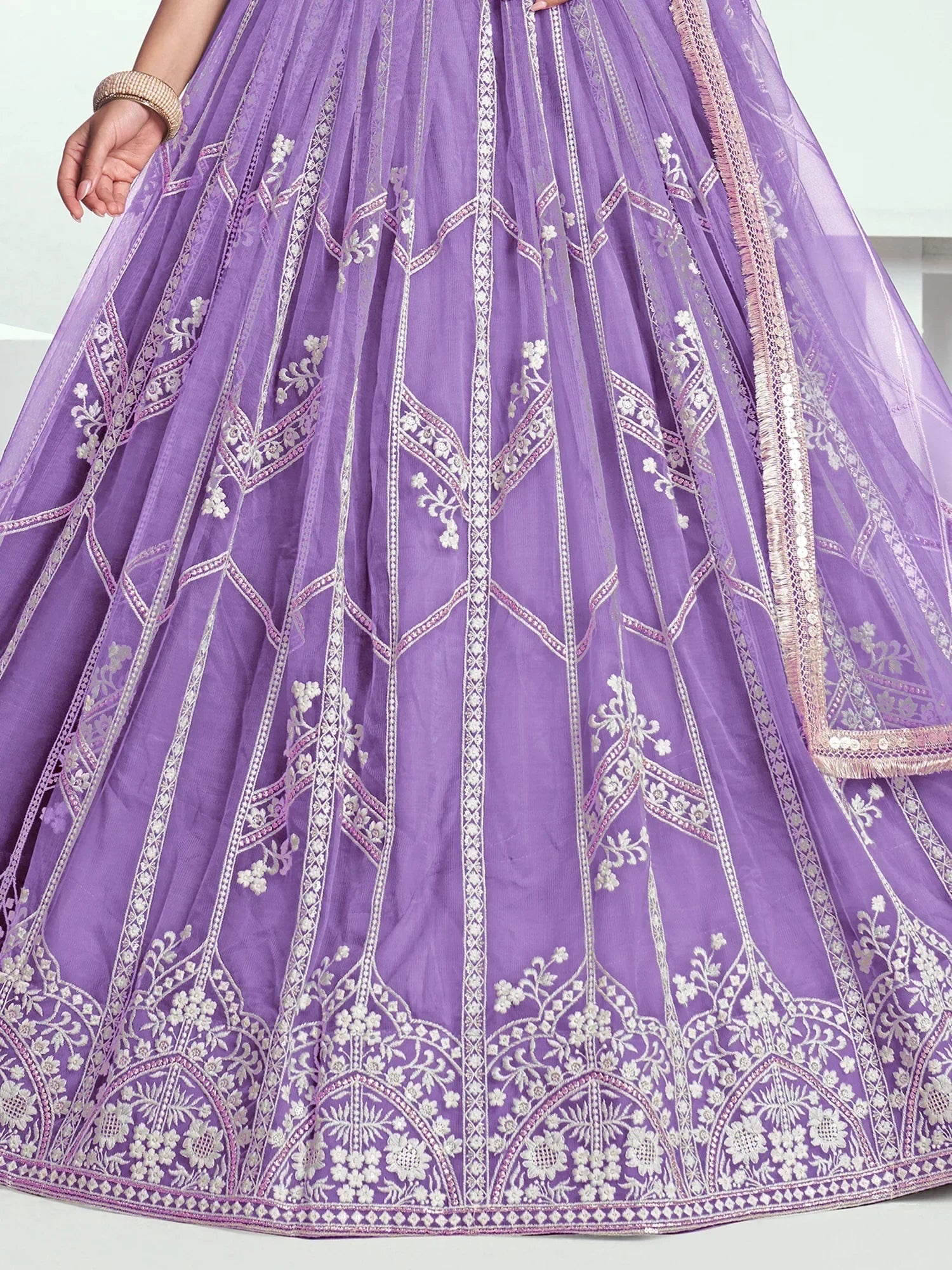 Lavender lehenga with intricate white floral embroidery and geometric patterns, perfect for Indian ethnic wear.