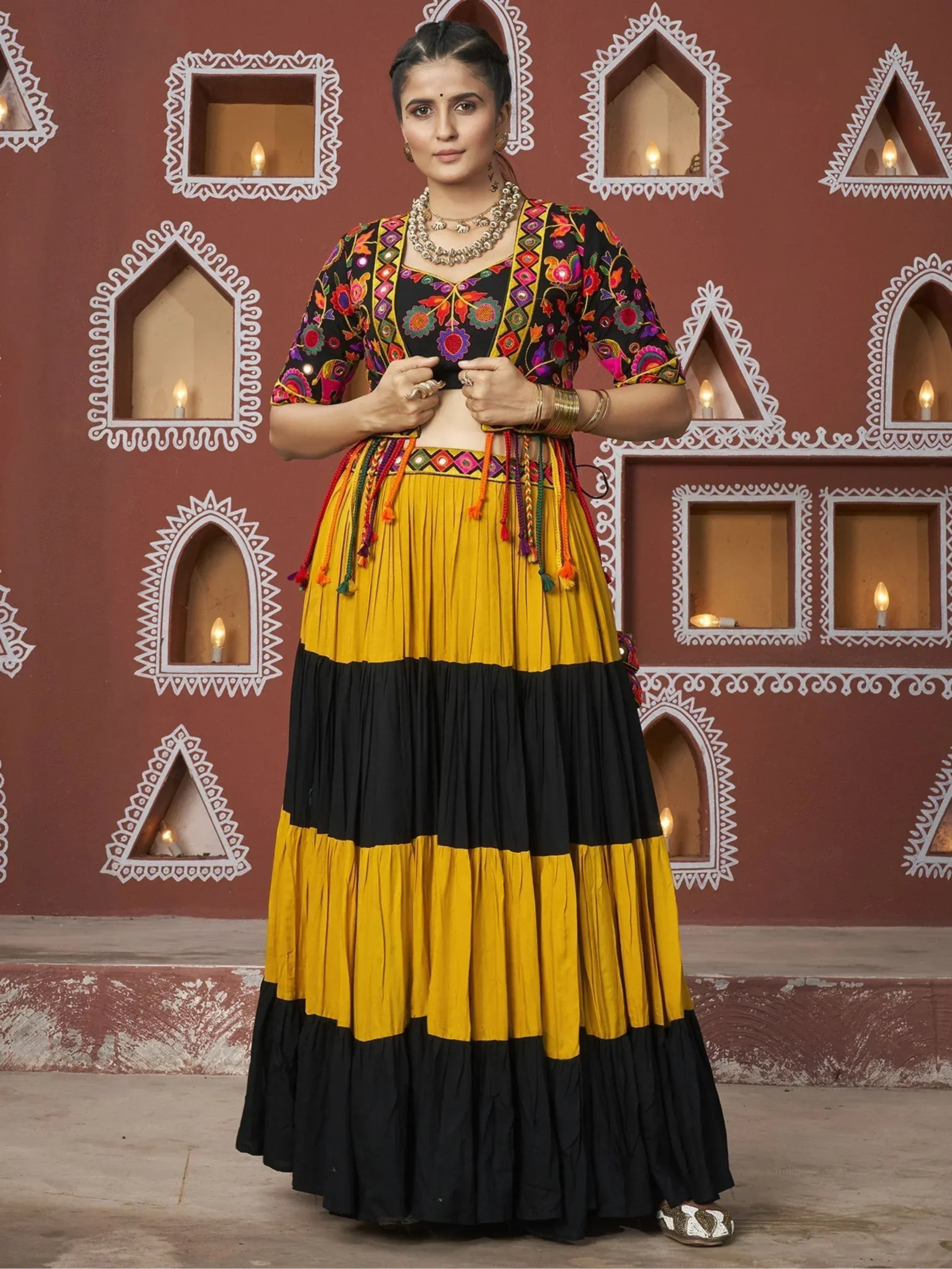 Black and mustard yellow embroidered lehenga choli with colorful tassels, perfect for Indian ethnic wear