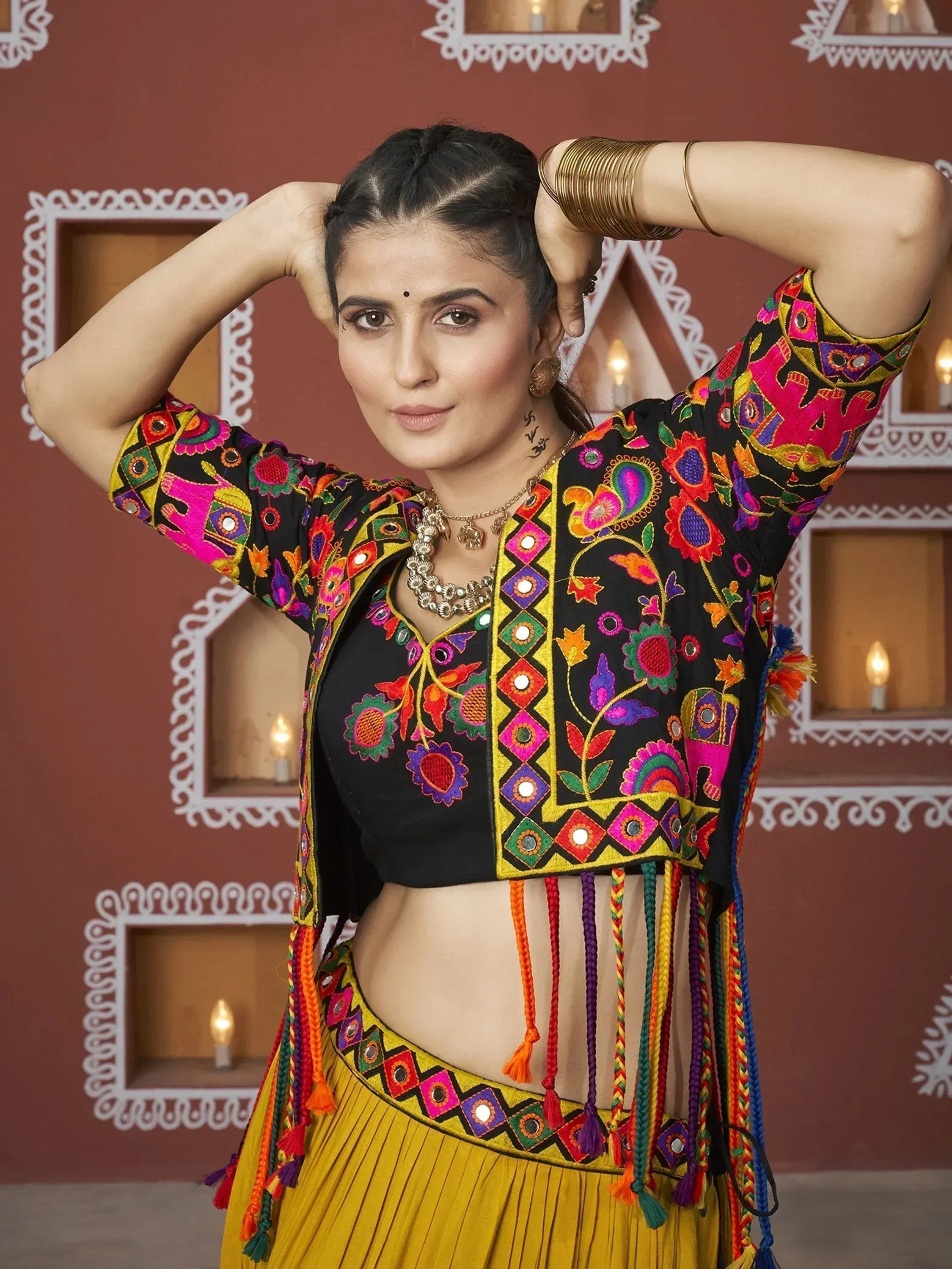 Vibrant Indian ethnic wear with mirror work, floral embroidery, and tassels on black and yellow lehenga choli