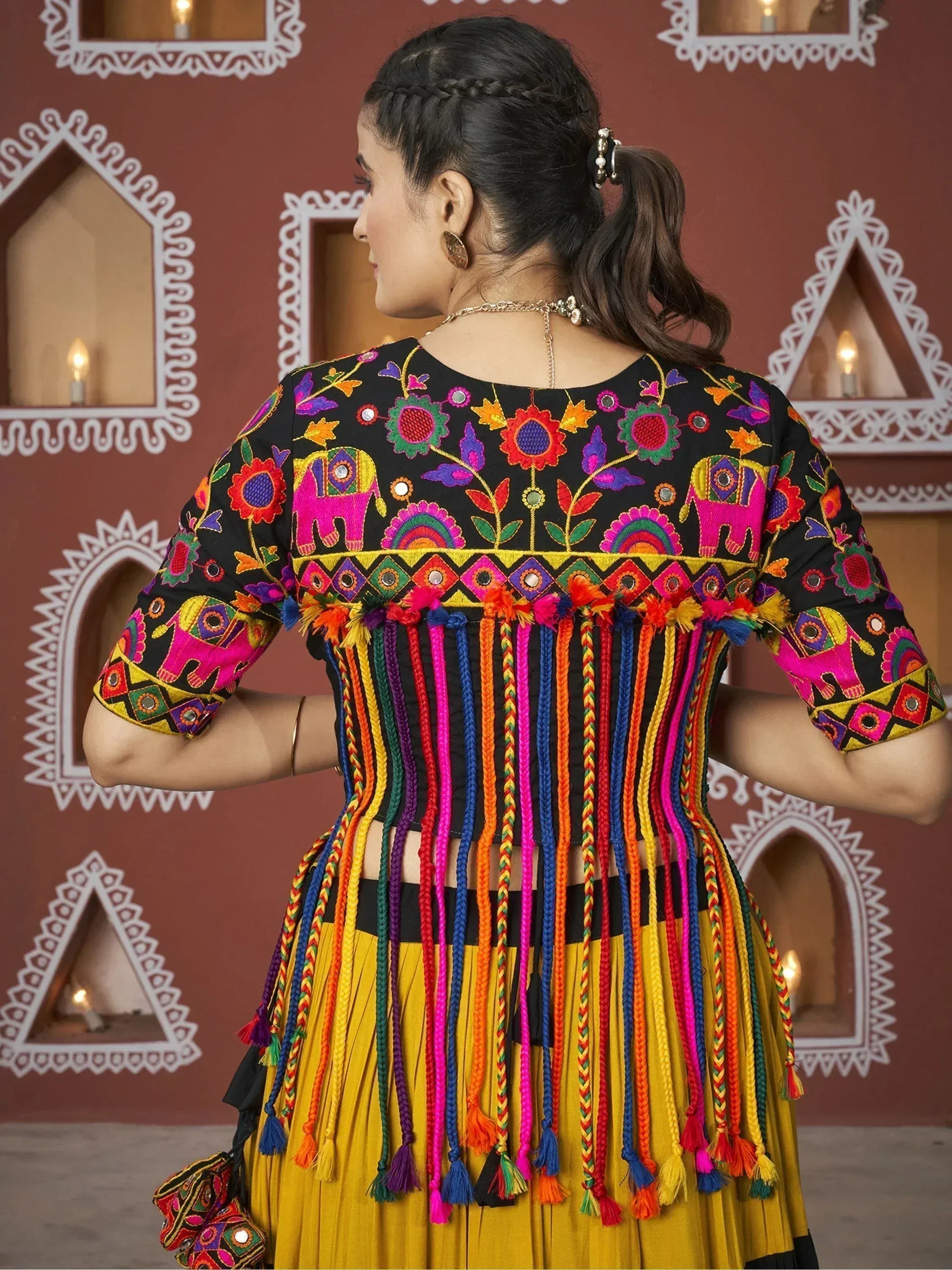 Black and yellow ethnic top with colorful elephant embroidery and tassels, paired with pleated skirt