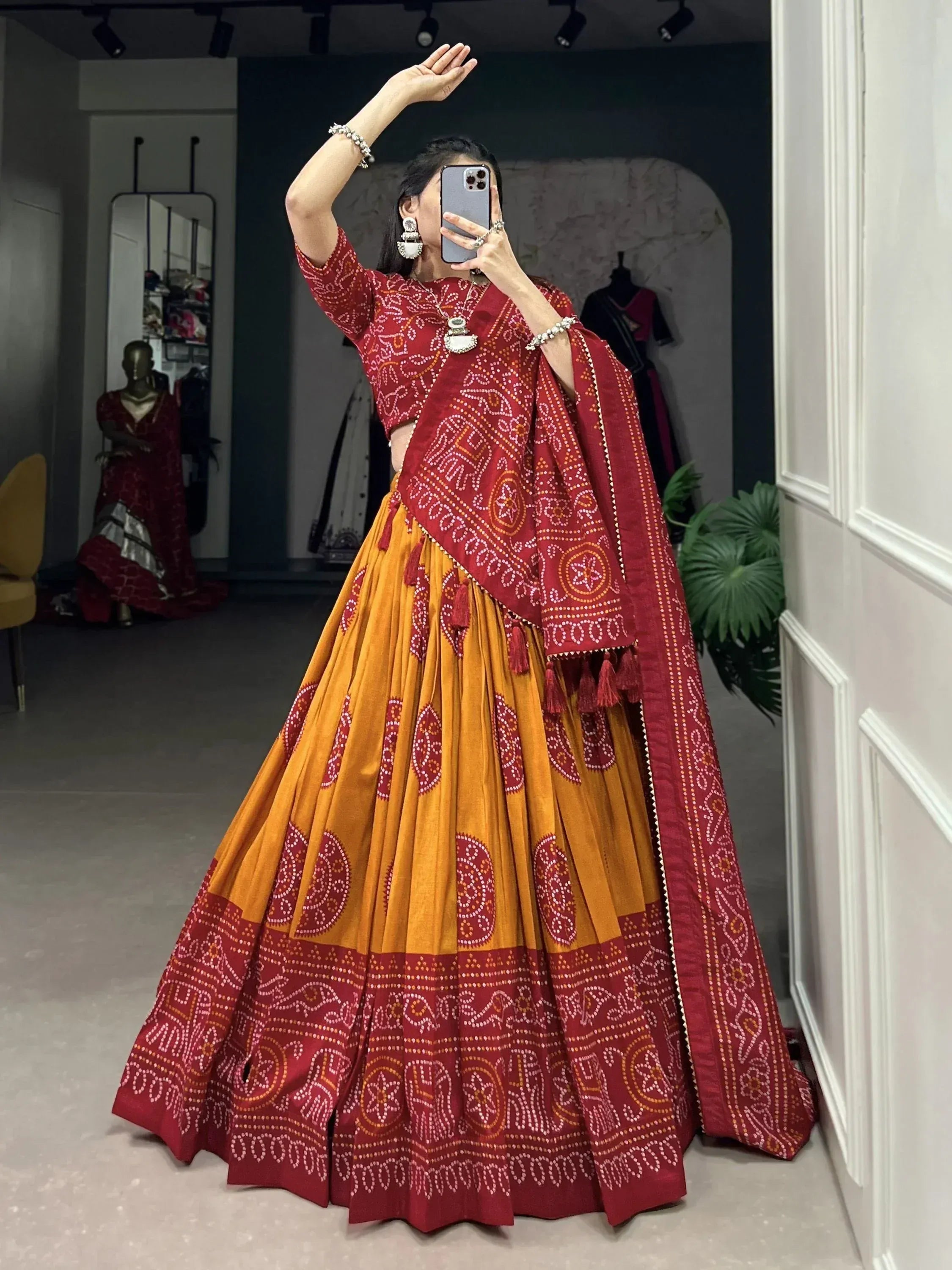 Red and mustard Bandhani print lehenga choli with mirror work, perfect for Indian ethnic wear occasions.