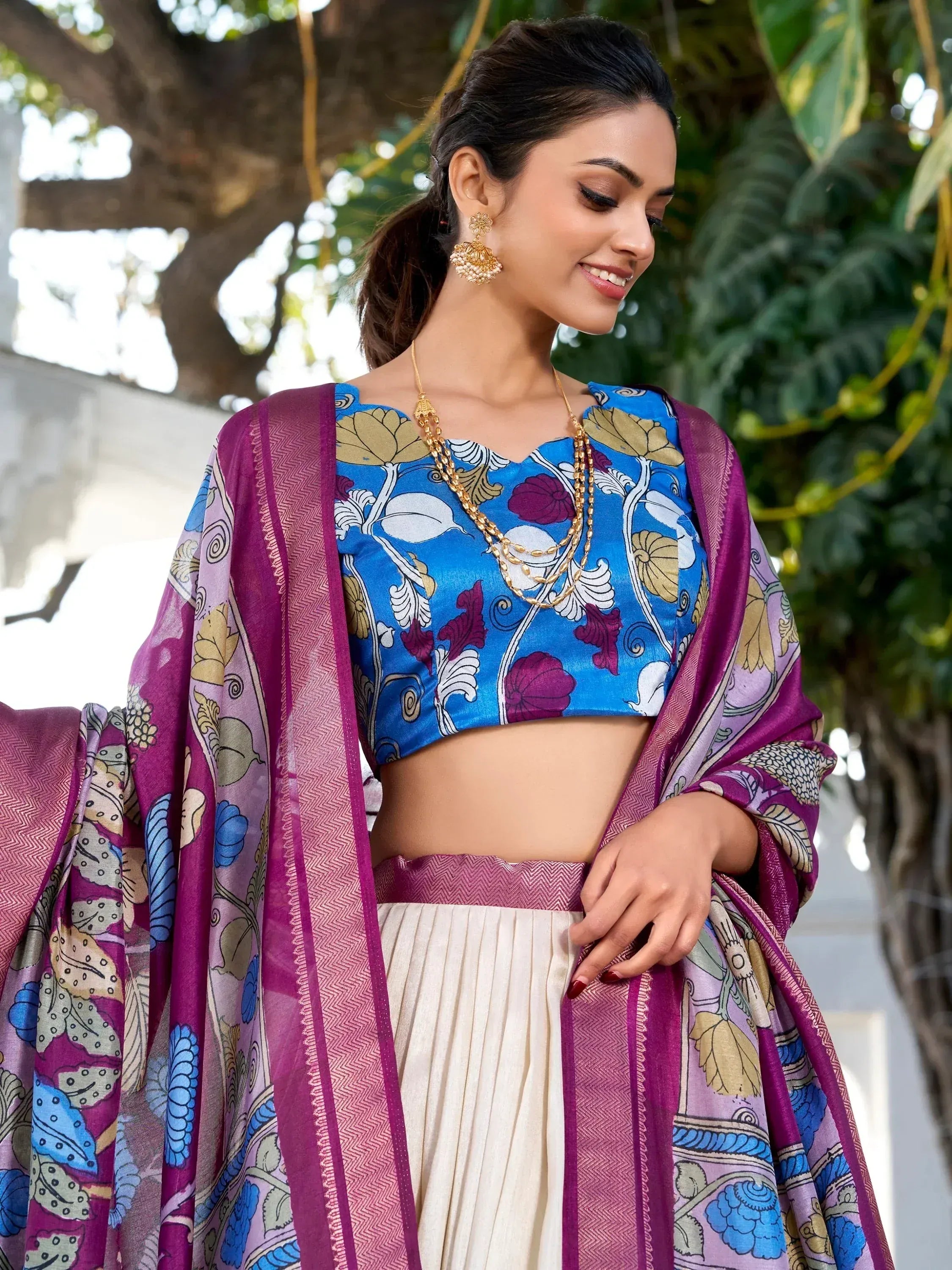 Woman in blue floral crop top with purple dupatta and cream pleated skirt, Indian ethnic wear
