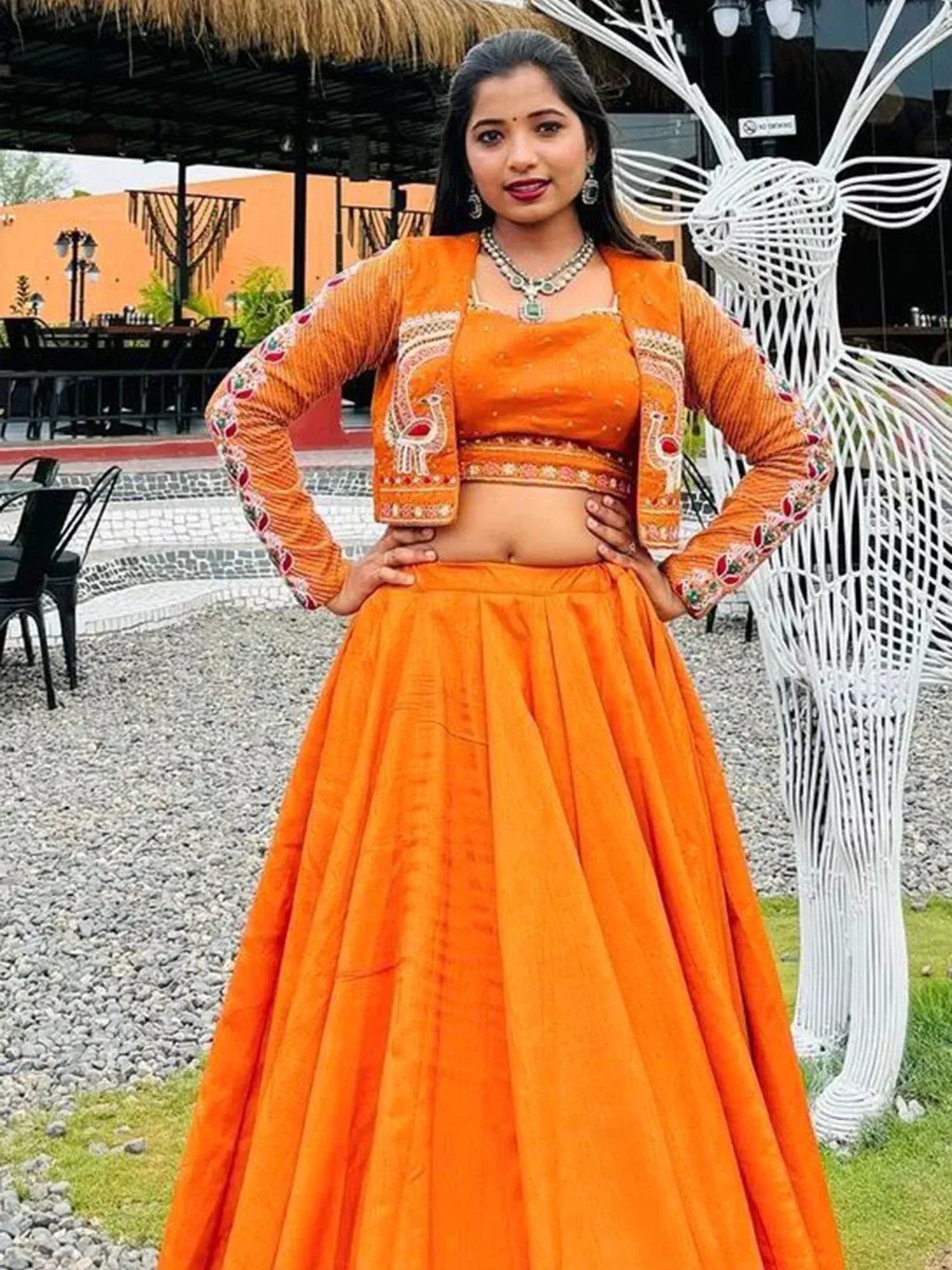 Vibrant orange designer lehenga choli with peacock embroidery, perfect for Indian ethnic wear events.