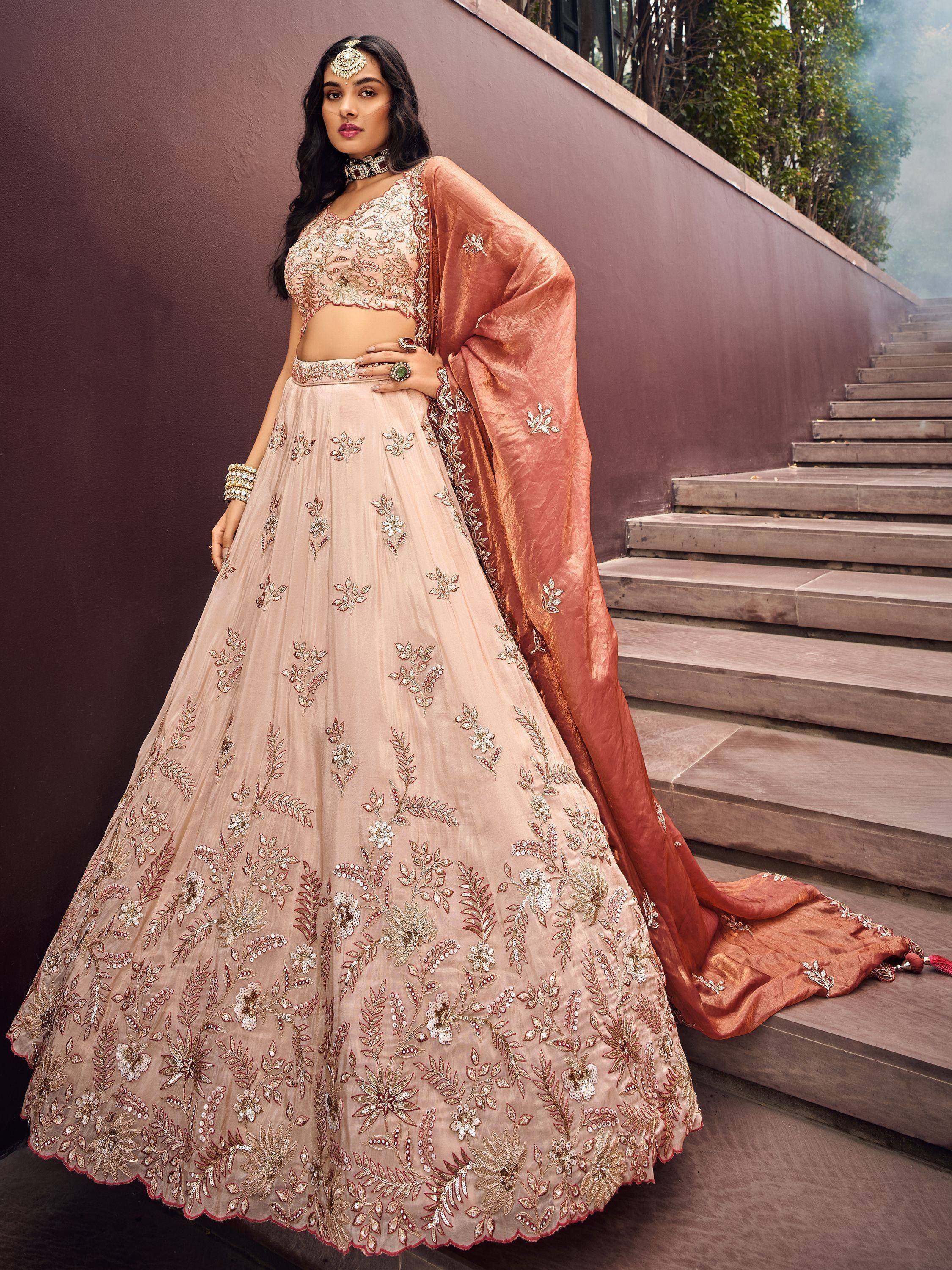 Elegant blush pink embroidered lehenga choli with floral motifs and matching dupatta, perfect for Indian weddings or festive occasions.