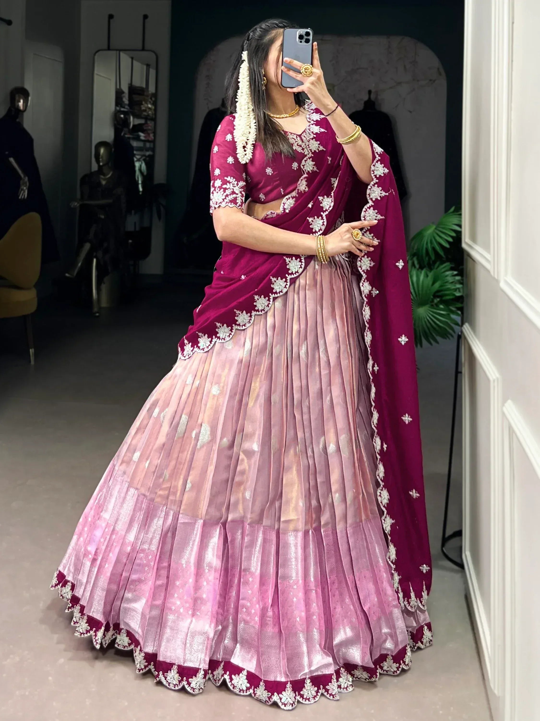 Woman in maroon and pink embroidered lehenga choli with floral detailing, perfect for Indian ethnic wear occasions.