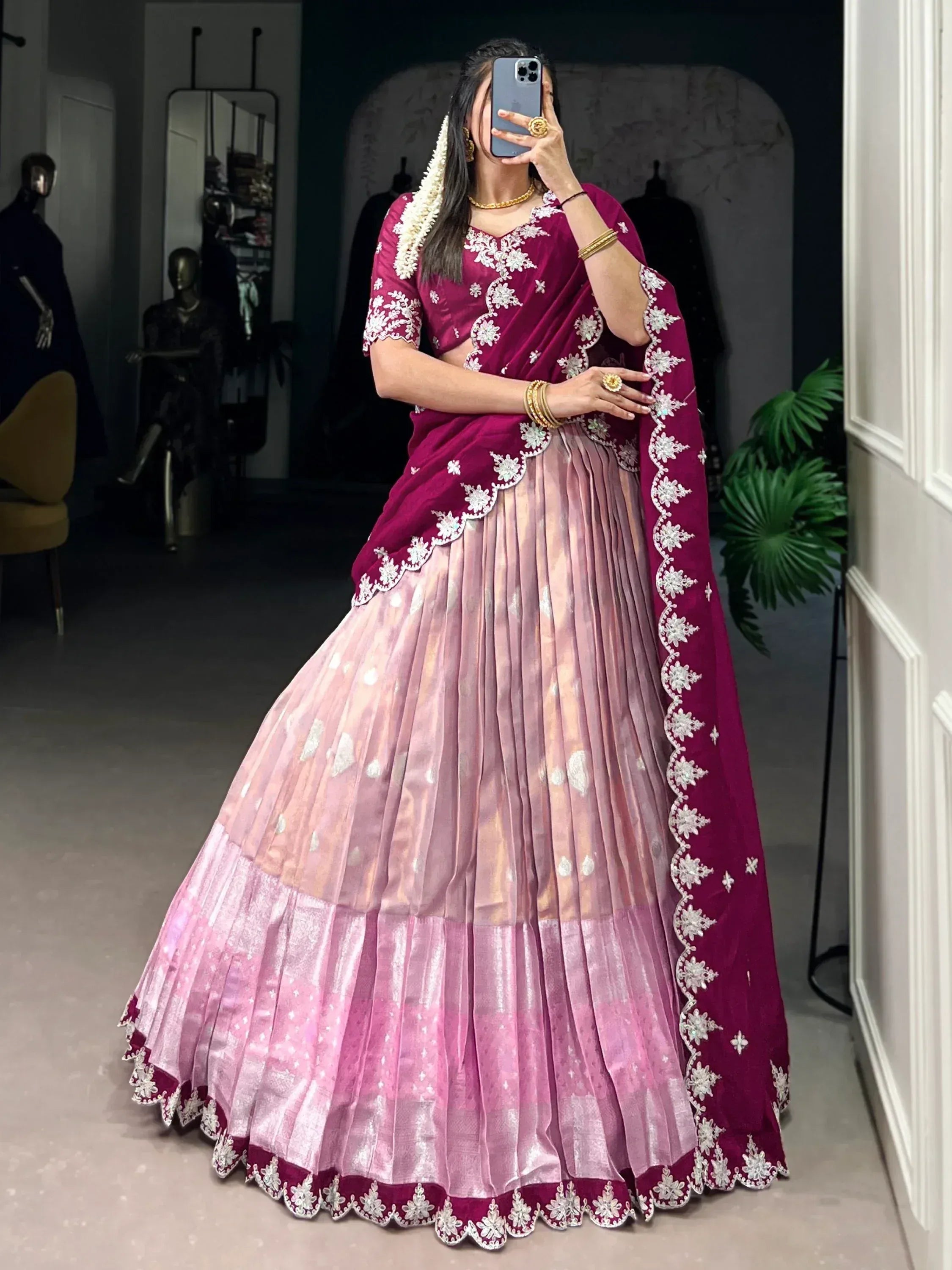 Woman in maroon and pink embroidered lehenga choli with floral detailing, perfect for Indian ethnic wear occasions.