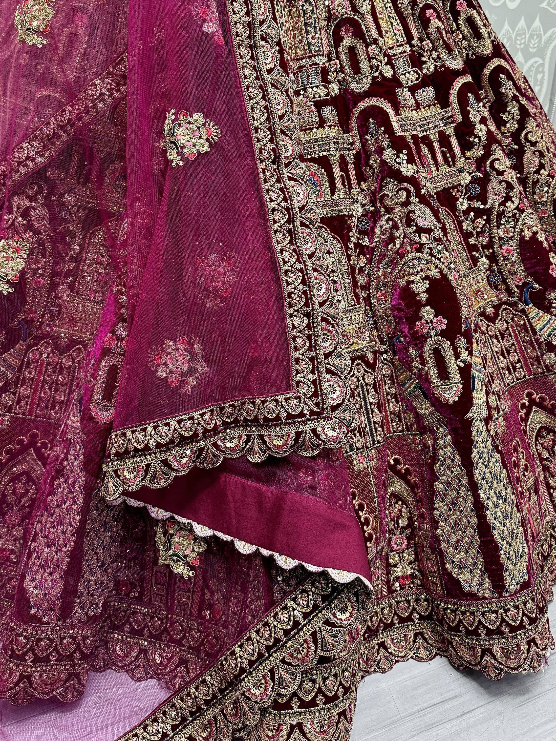 Luxury maroon velvet lehenga with intricate gold embroidery and peacock motifs, perfect for Indian weddings.